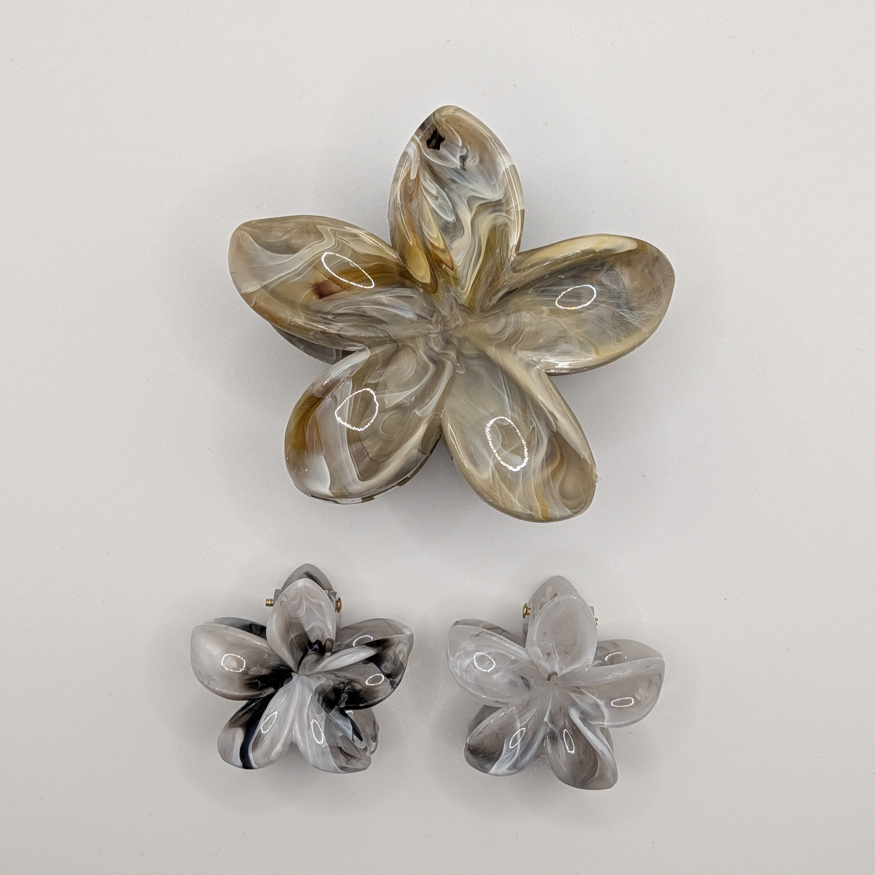 Marmoriertes Braun - 3-piece set showing one medium amber marbled flower clip and two small grey flower clips.

3-teiliges Set bestehend aus einer bernsteinfarbenen und zwei grauen Blumen-Haarklammern.