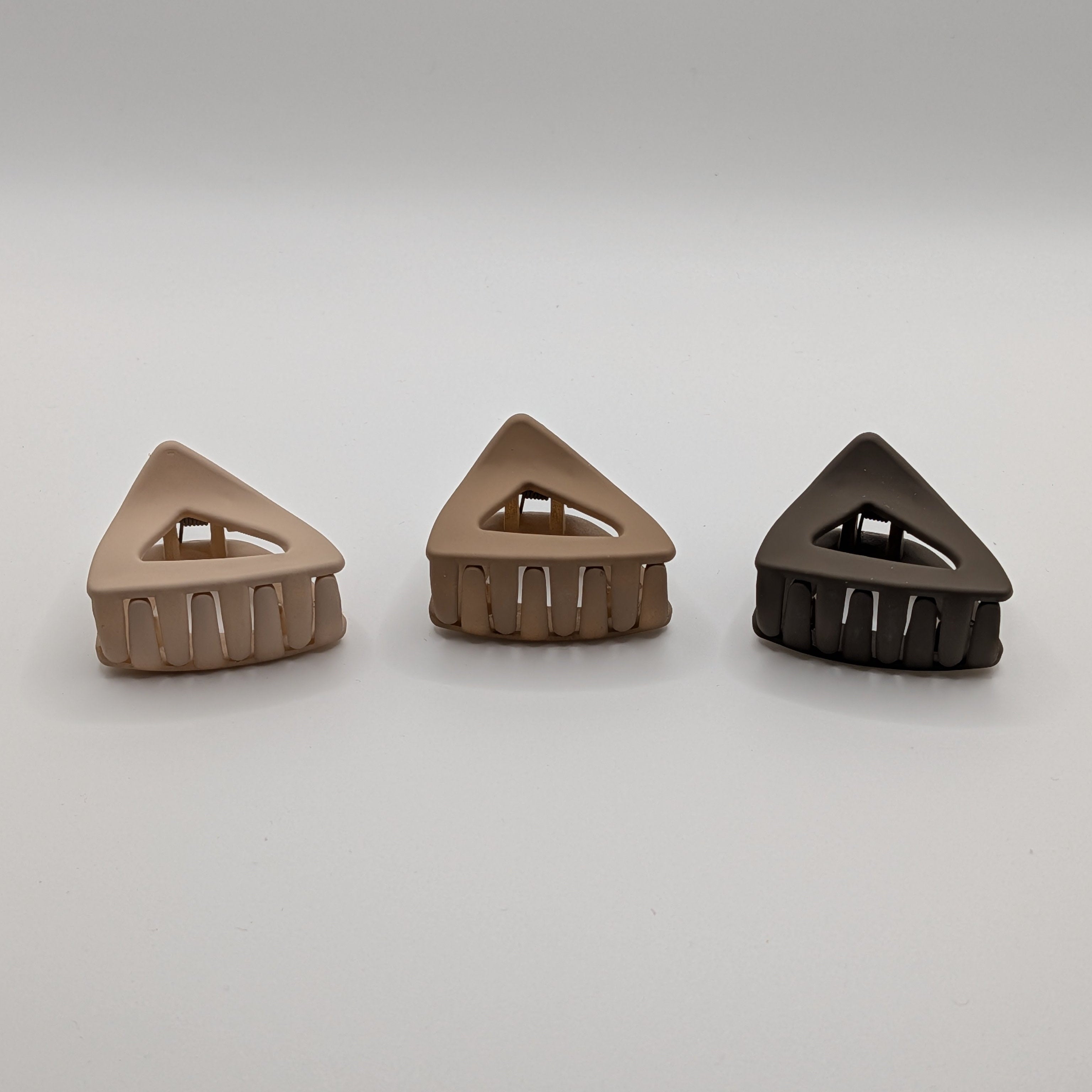Front view of a 3-piece set of 4cm matte triangle hollow hair clips showing the frame and teeth.	

Frontansicht eines 3er-Sets 4cm matter dreieckiger Haarklammern, die den Rahmen und die Zähne zeigt.