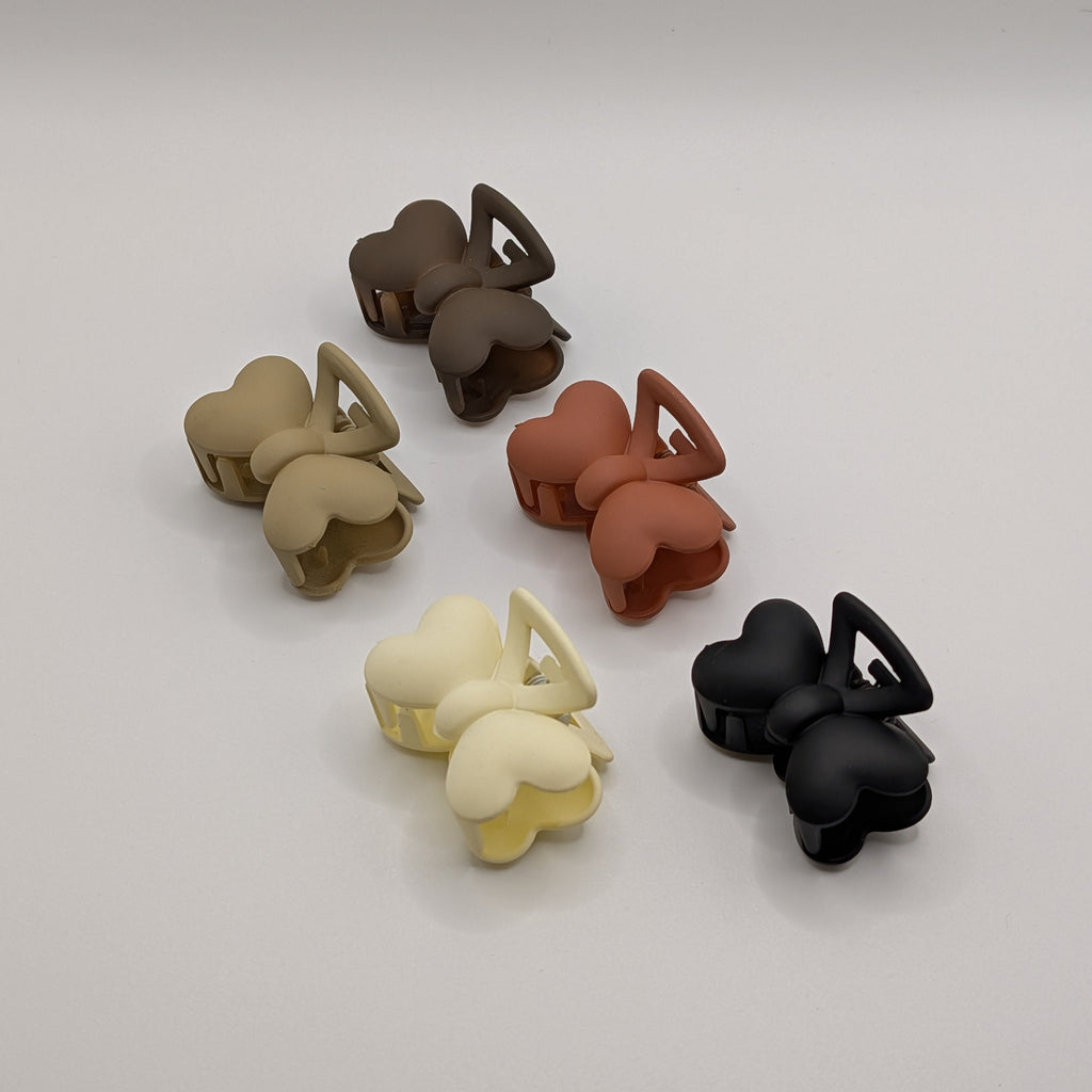 Angled group shot of aesthetic earthy-toned butterfly hair clips for small business product listing.	

Gruppenbild von ästhetischen Schmetterlings-Haarklammern in Erdtönen für den Online-Shop.