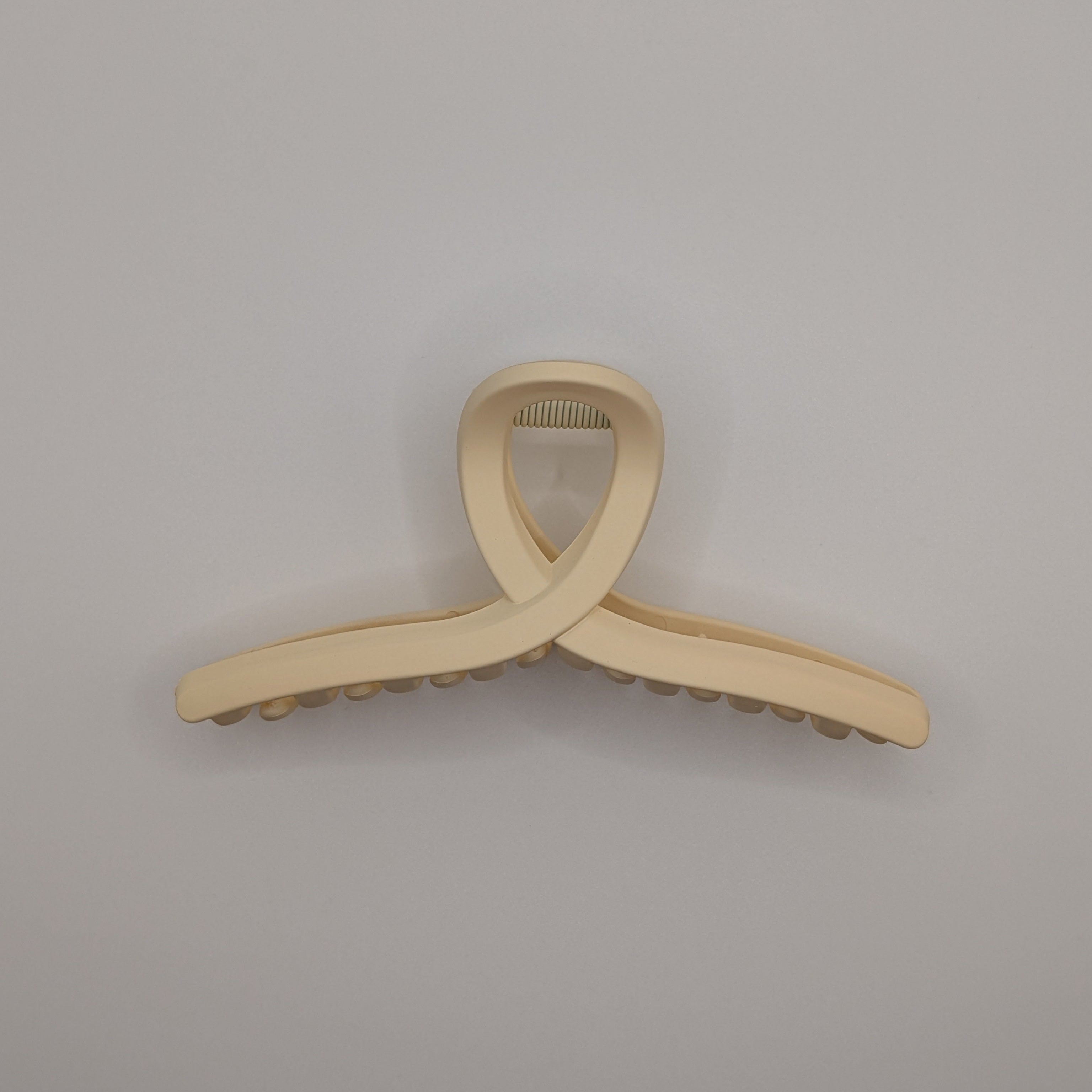 Beige - Top view of a matte cream cross-loop hair claw clip.

Draufsicht einer matten cremefarbenen Haarklammer mit Kreuzschleife