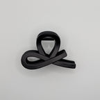 Matt Schwarz - Side view of a minimalist black infinity loop hair clip on a white background.	

Seitenansicht einer minimalistischen schwarzen Unendlichkeits-Haarklammer auf weißem Hintergrund.