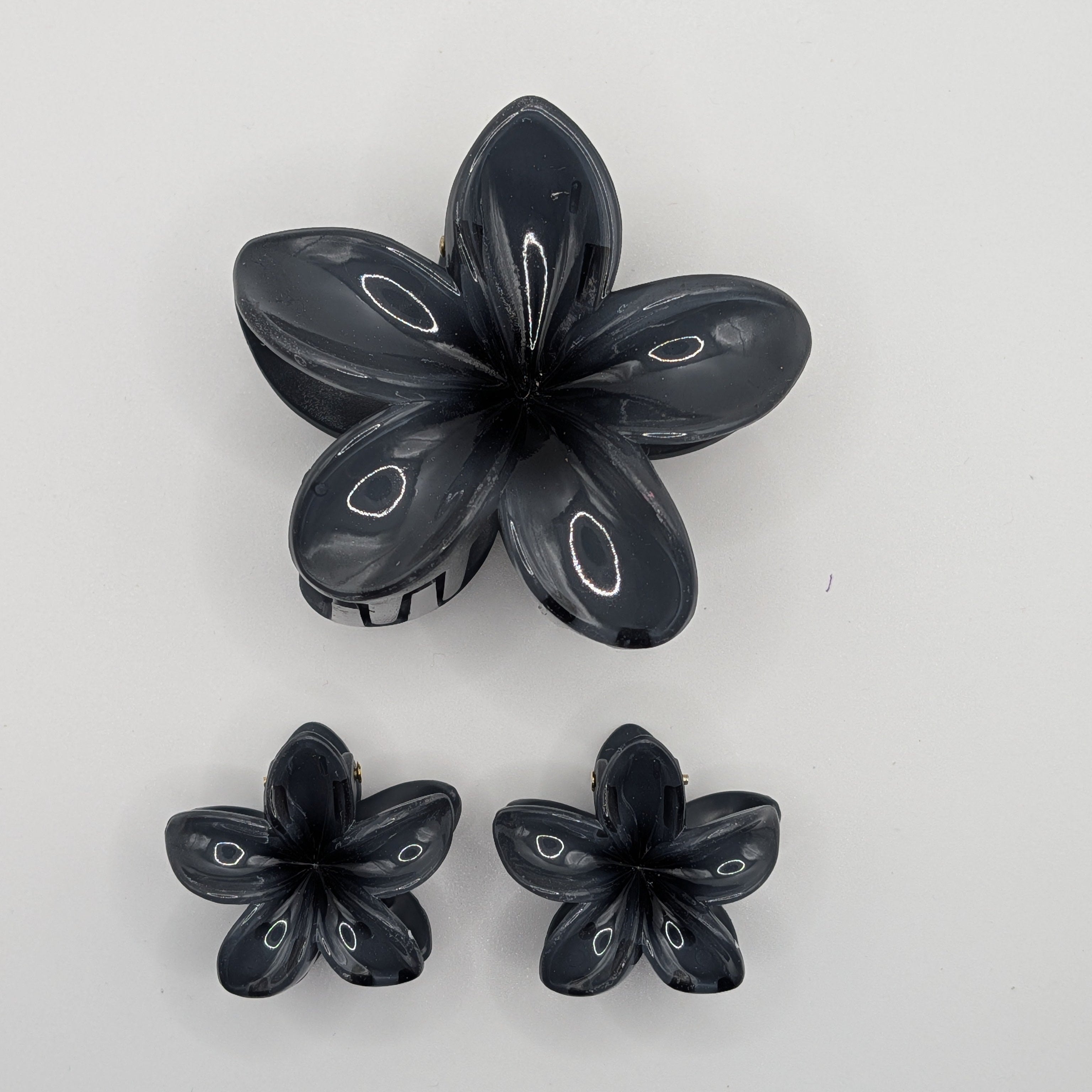 Rauchschwarz - 3-piece set of black marble floral hair claw clips featuring one medium and two small sizes.

3er-Set schwarz-marmorierte Blumen-Haarklammern, bestehend aus einer mittleren und zwei kleinen Größen.