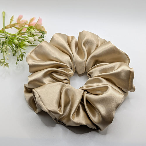 3er Set - Elegant champagne gold satin scrunchie displayed on a white background.	

Elegantes champagner-goldenes Satin-Haargummi auf weißem Hintergrund.