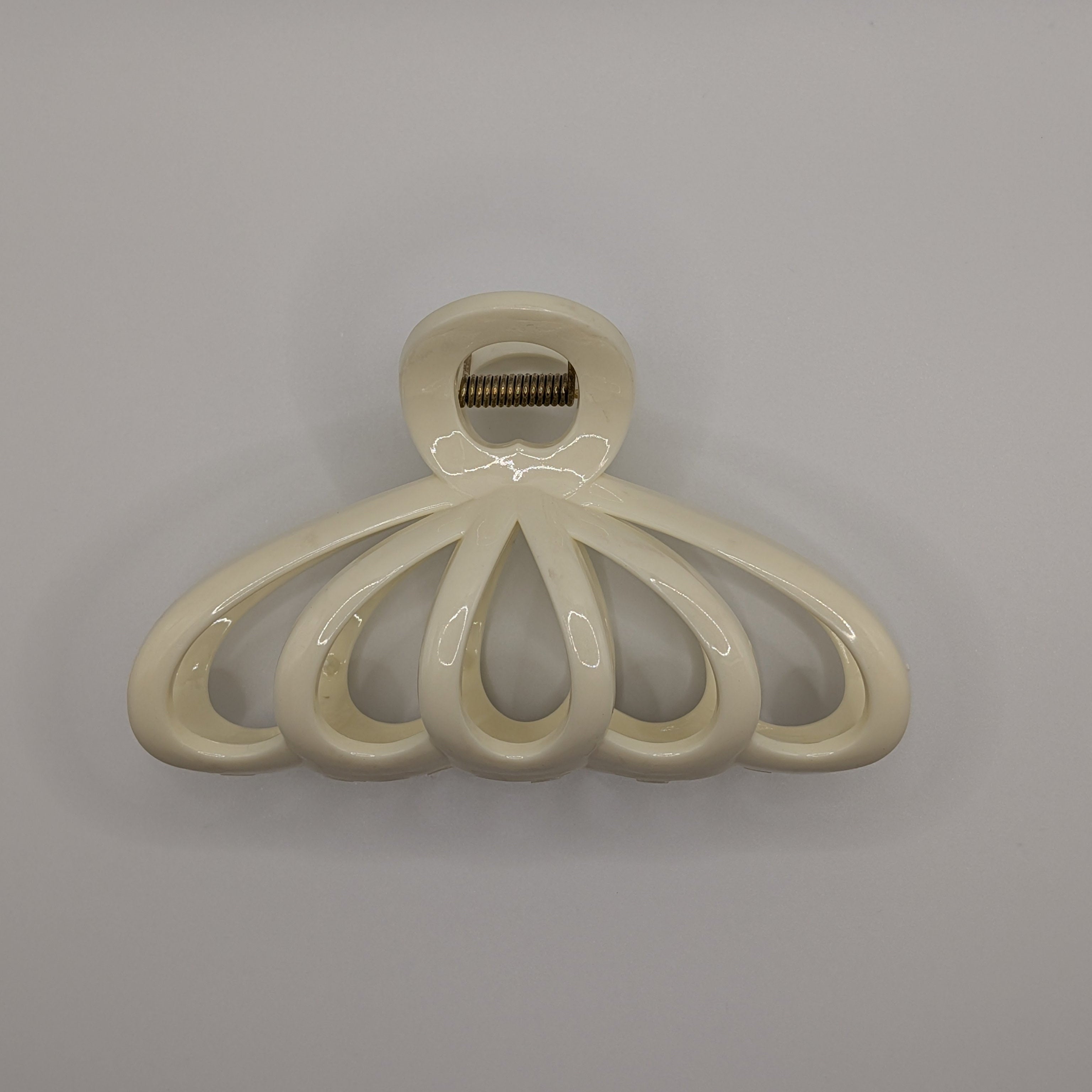 Creme - Front view of a cream-colored fan-shaped hair claw clip on a white background.

Frontansicht einer cremefarbenen Haarklammer in Fächerform auf weißem Hintergrund.