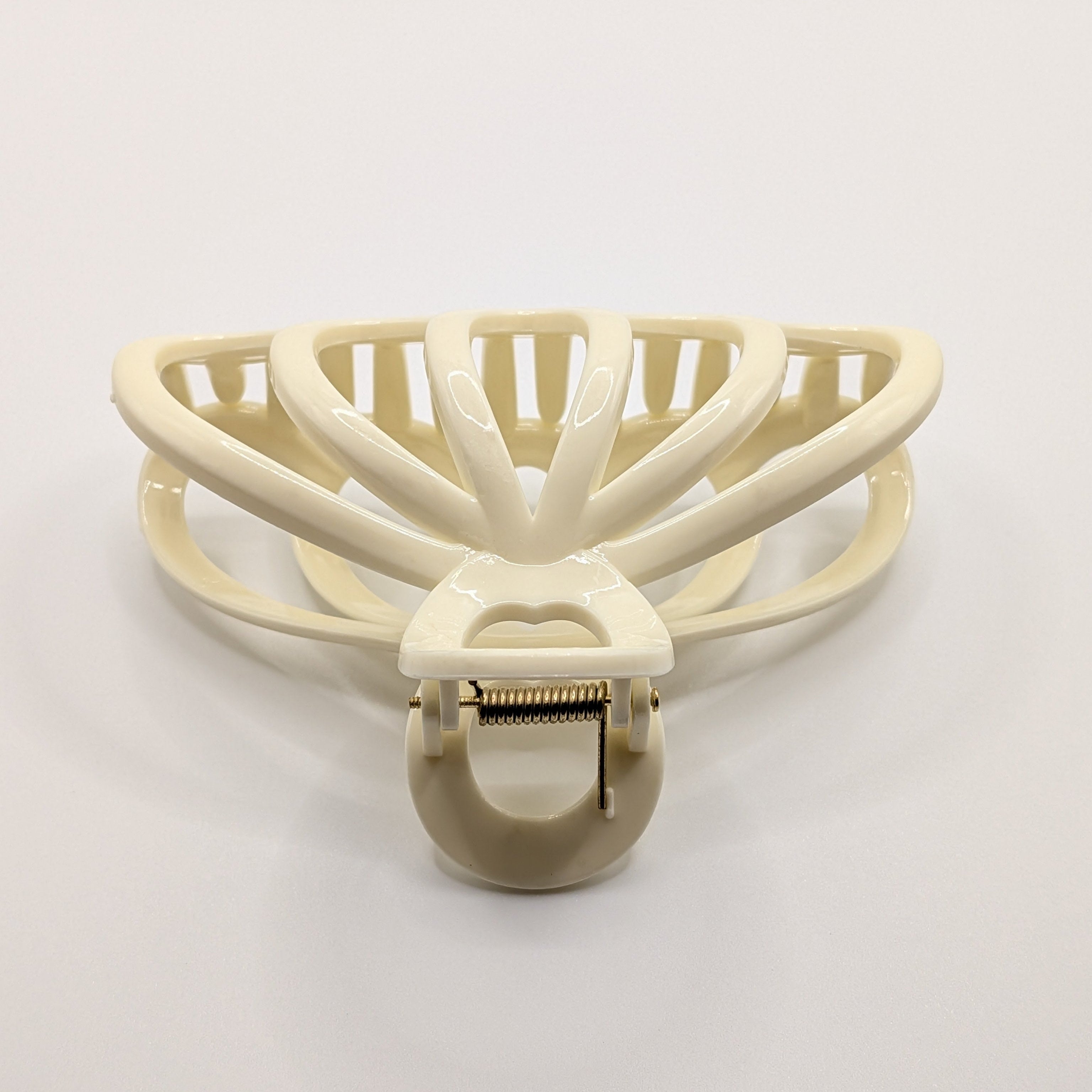 Creme - Top-down view showing the metal spring and internal structure of the claw clip.

Draufsicht auf die Metallfeder und die interne Struktur der Haarklammer.