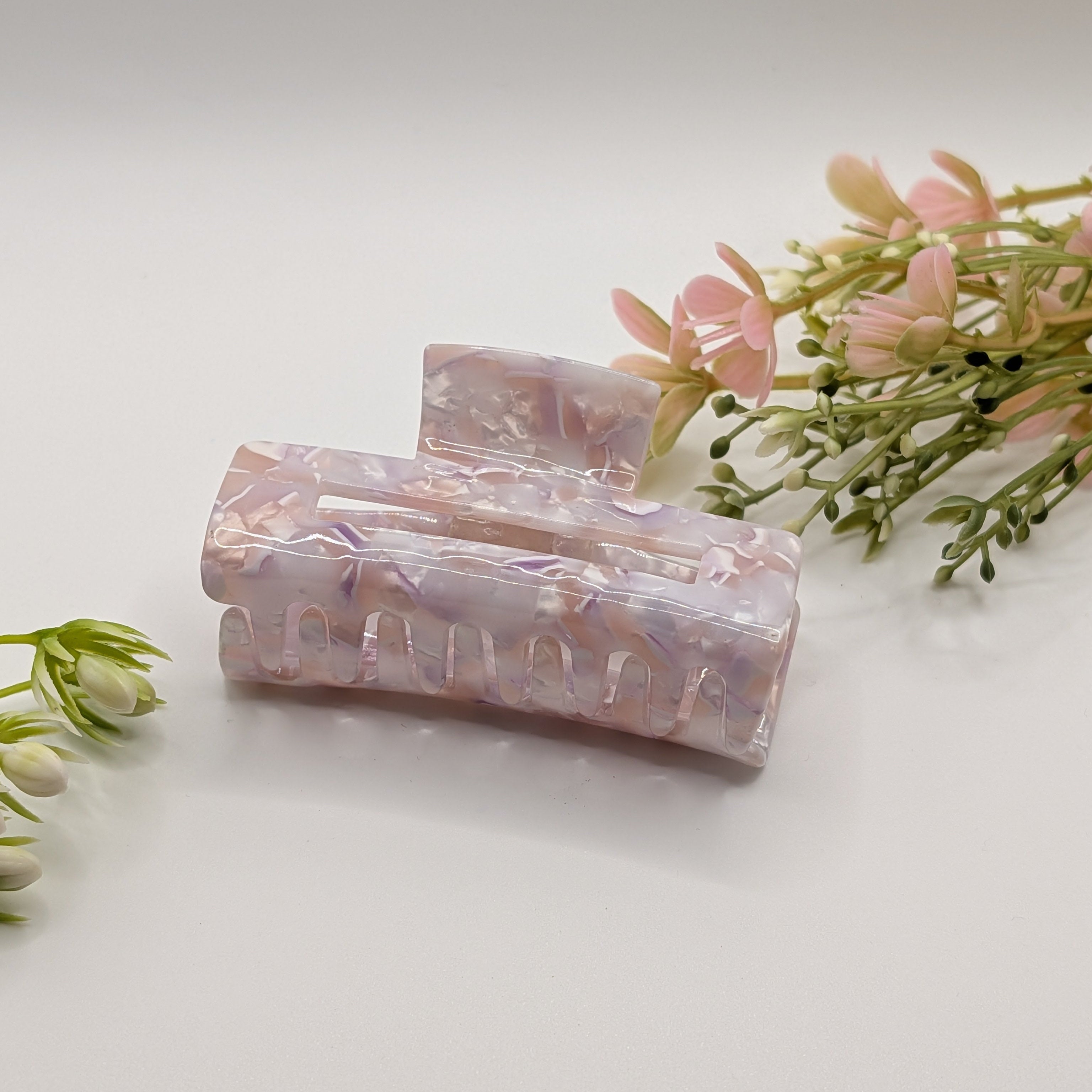 Lavendel-Traum - "Geo-Lavender Maxi" 7.5cm Haarspange - Mercy Haaraccessoires

Große Haarklammer aus Acryl mit fliederfarbenem Marmormuster, präsentiert mit rosa Blumen auf weißem Grund.