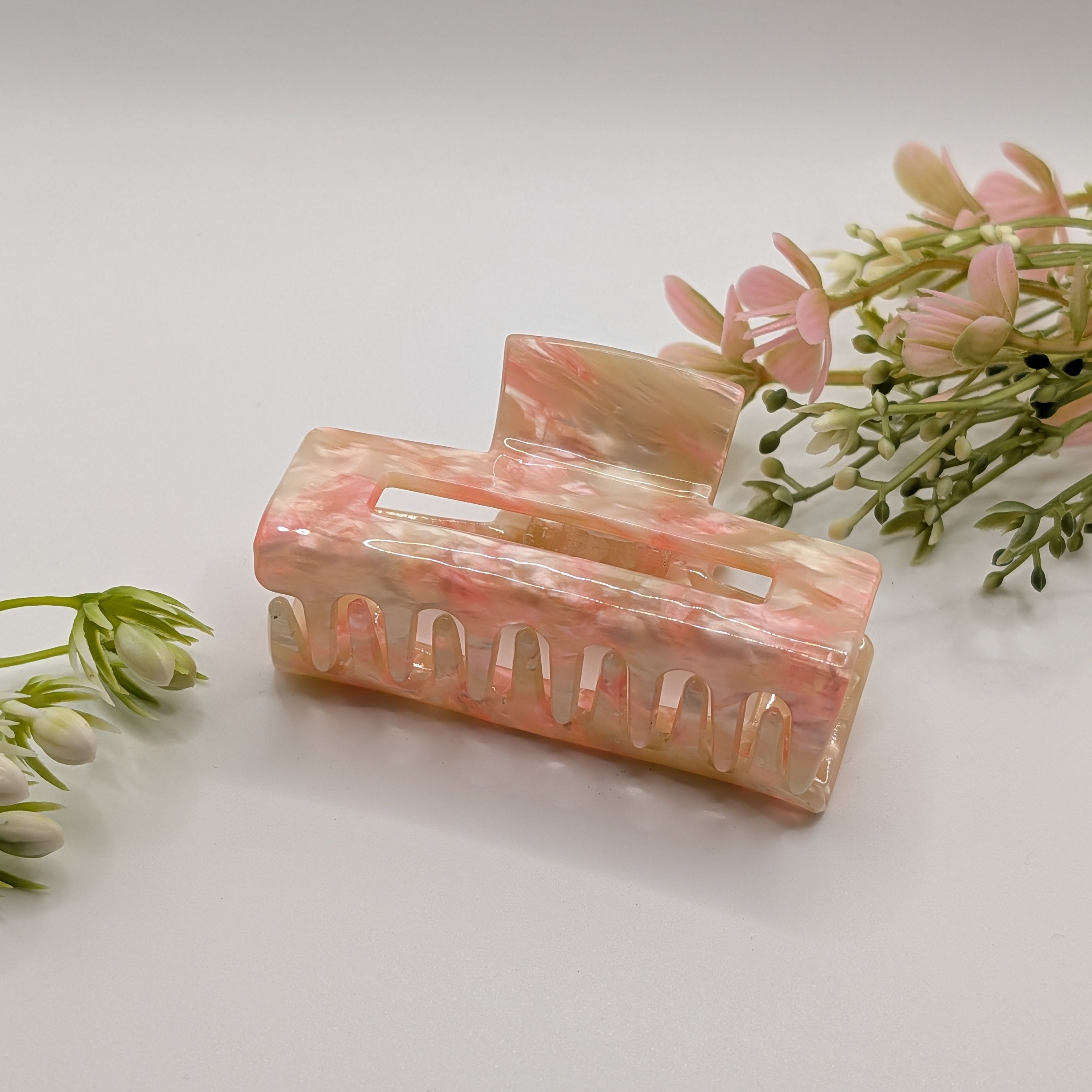 Pfirsich-Sorbet - "Geo-Summer Maxi" 7.5cm Haarspange - Mercy Haaraccessoires

Breite, rechteckige Haarklammer aus rosa-weiß marmoriertem Acryl, liegend neben rosa Frühlingsblumen auf weißem Hintergrund.