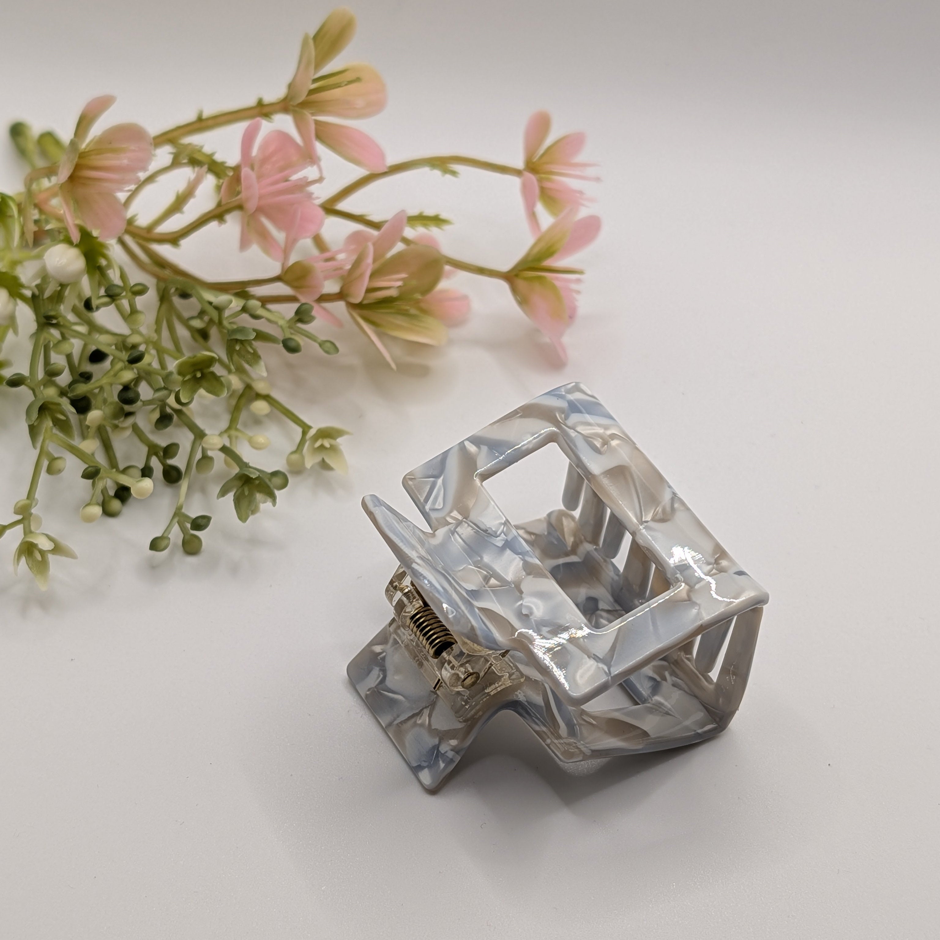 Arktisblau Marmoriert - Haarspange „Geo-Achat“ | Eisblau-Achat - Mercy Haaraccessoires

Eine blau-beige marmorierte Haarklammer in Schrägansicht, im Hintergrund dekorative rosa Blumen auf weißem Grund.