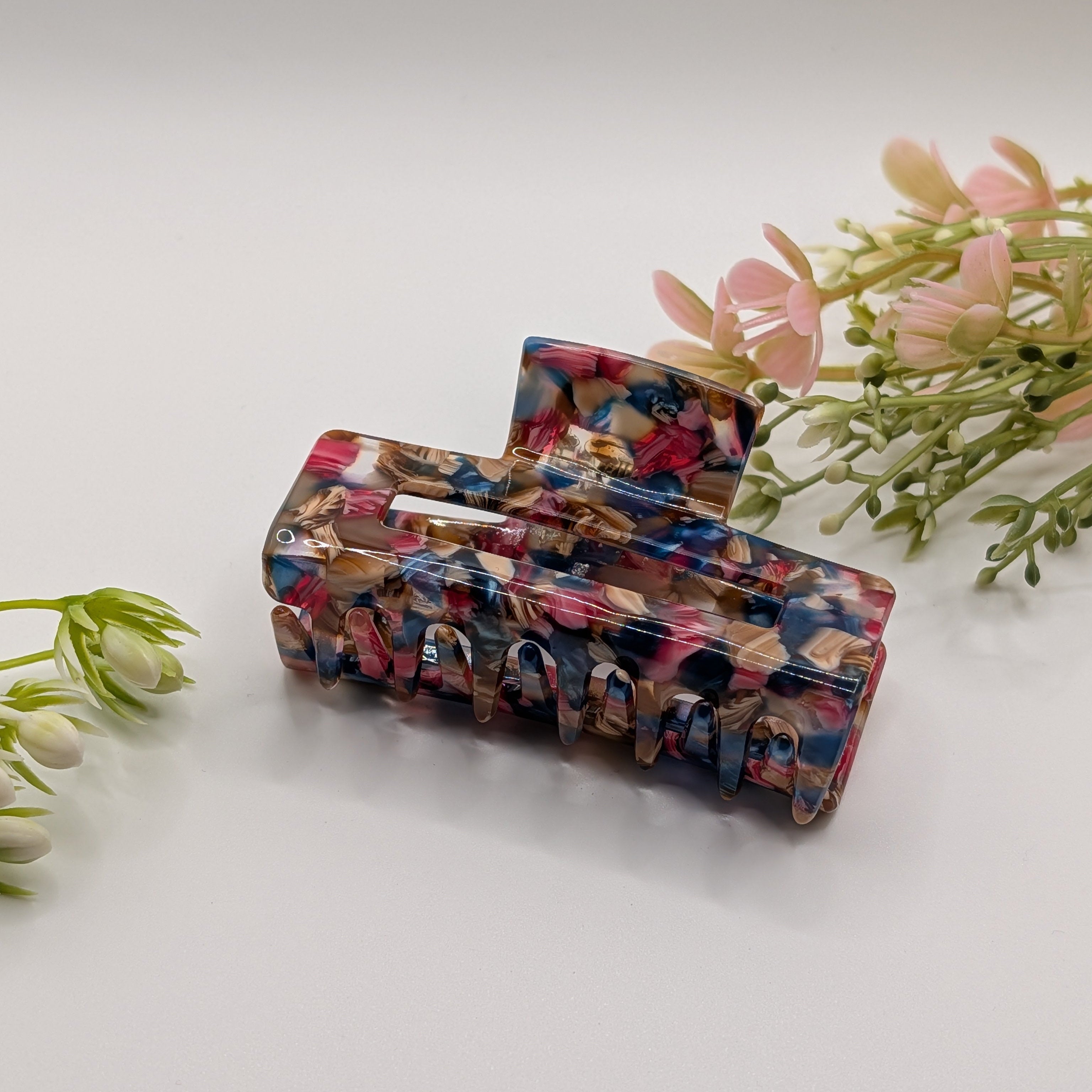 Abstrakter Sunset Mix - "Geo-Floral Maxi" 7.5cm Haarspange - Mercy Haaraccessoires

Rosa-blau marmorierte Haarklammer präsentiert in einer hellen Umgebung mit floraler Dekoration.