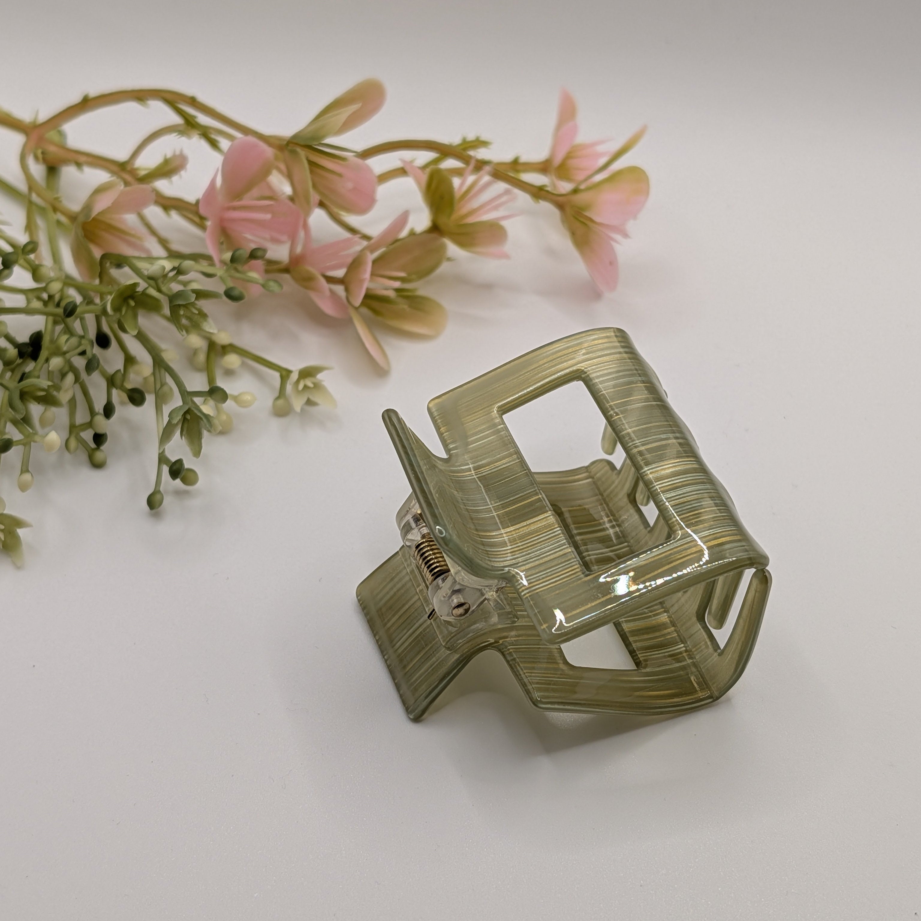 Gold-Moos Gestreift - Haarspange „Classic Evergreen“ | Transluzentes Hellgrau-Grün - Mercy Haaraccessoires

Eine grün gestreifte Haarklammer in der Schrägansicht, dekoriert mit zartrosa Blumen auf hellem Hintergrund.