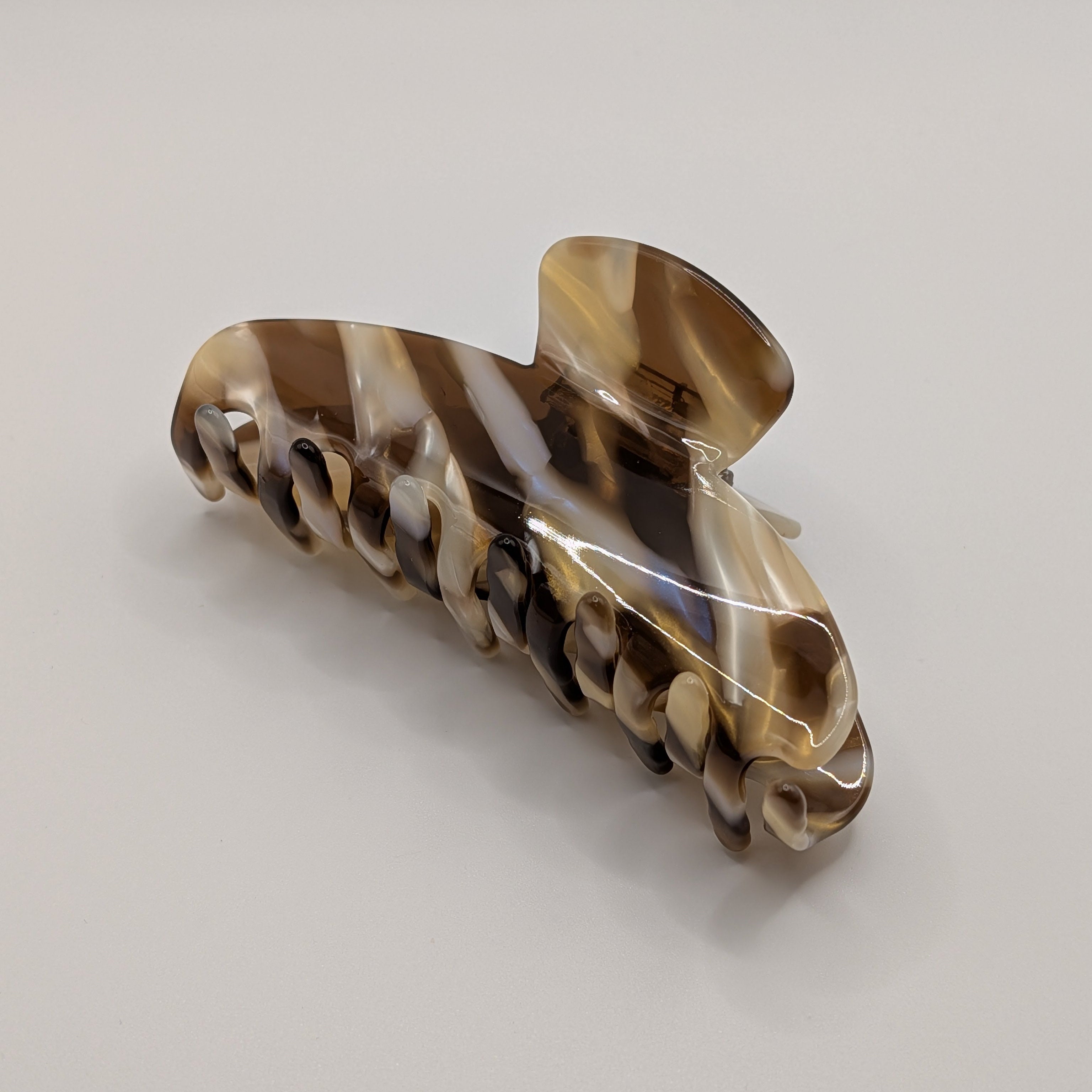 Klassisches Schildpatt - "Cappuccino Wave" – 10cm Luxus Acetat Haarklammer - Mercy Haaraccessoires

Große marmorierte Haarklammer in Braun und Beige neben zarten Frühlingsblumen.