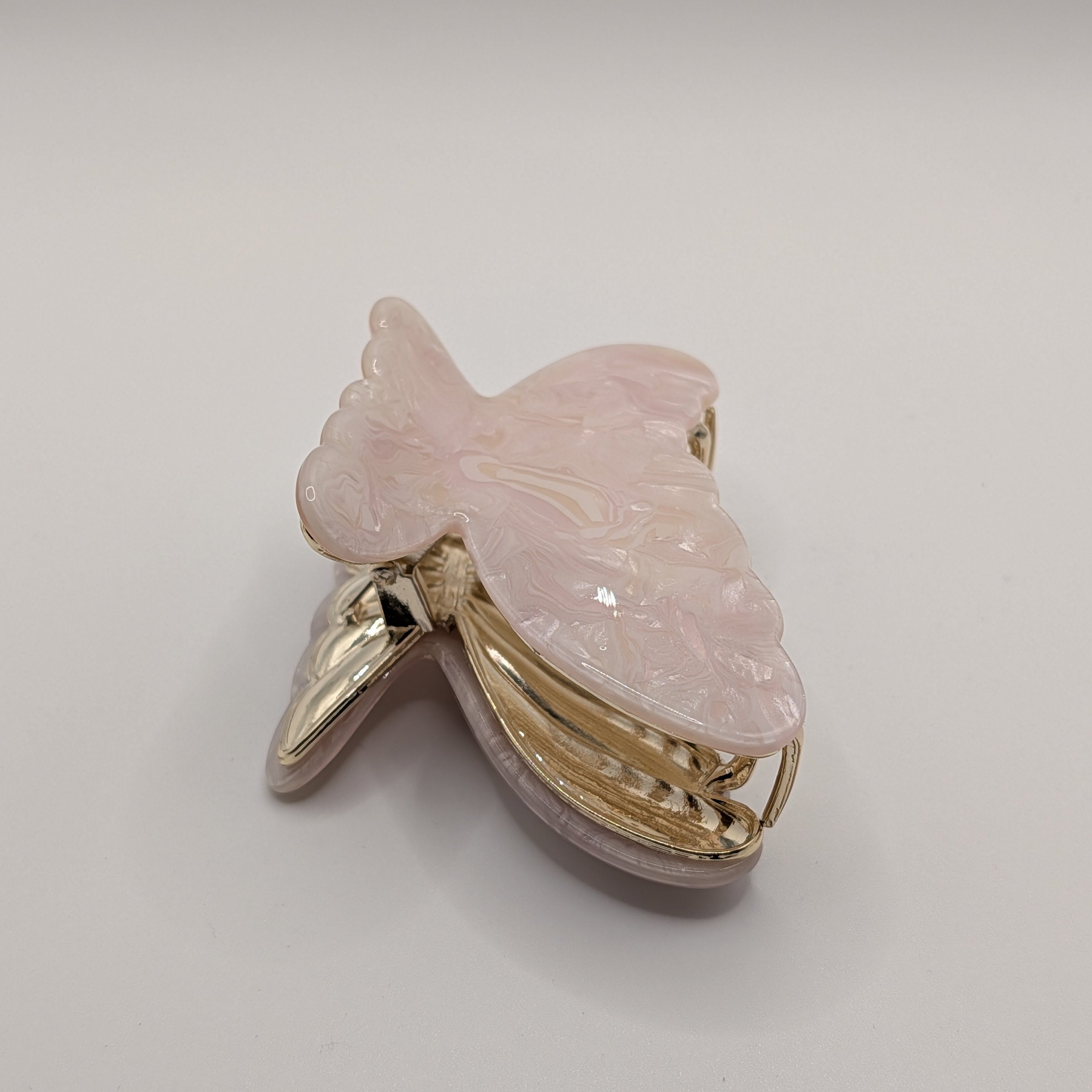 Perlglanz Rosa - Haarspange „Pink Angel“ | Rosé-Quarz-Marmor - Mercy Haaraccessoires

Elegante Haarklammer in Schmetterlingsform aus pastellrosa Acryl mit feiner Marmorierung und glänzendem Gold-Verschluss.