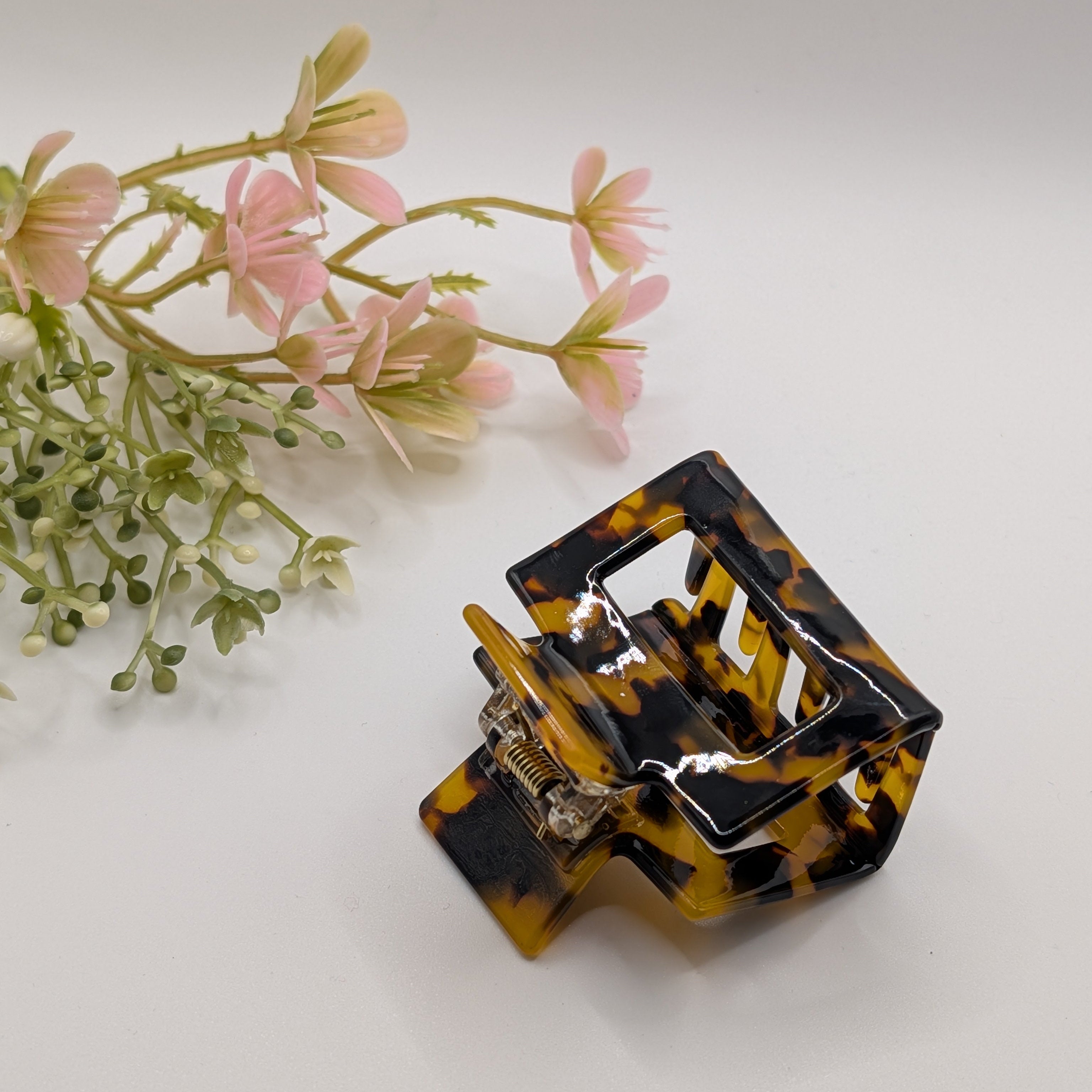 Klassisches Schildpatt - "Classic Havana" 5cm Mini-Haar-Klammer - Mercy Haaraccessoires

Schrägansicht einer Haarklammer mit Schildpatt-Muster auf weißem Grund mit dekorativen Blumen.