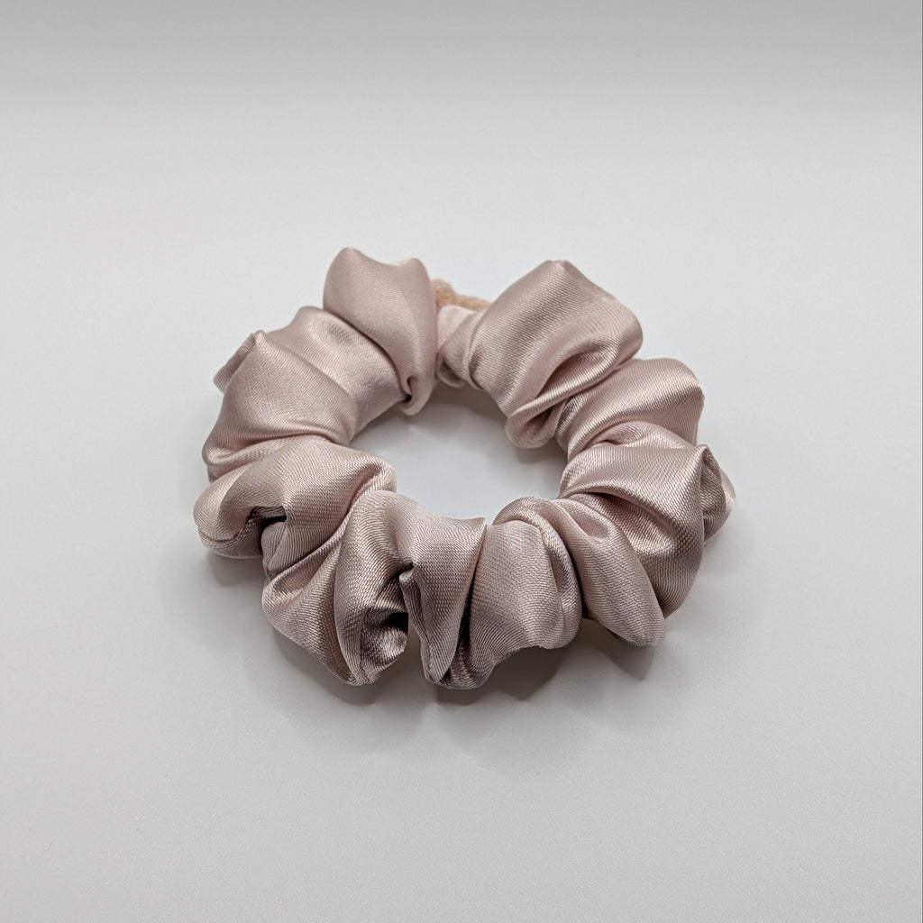 klein - Medium-sized rose gold satin hair tie on a white background.	

Mittleres roségoldenes Satin-Haargummi auf weißem Hintergrund.