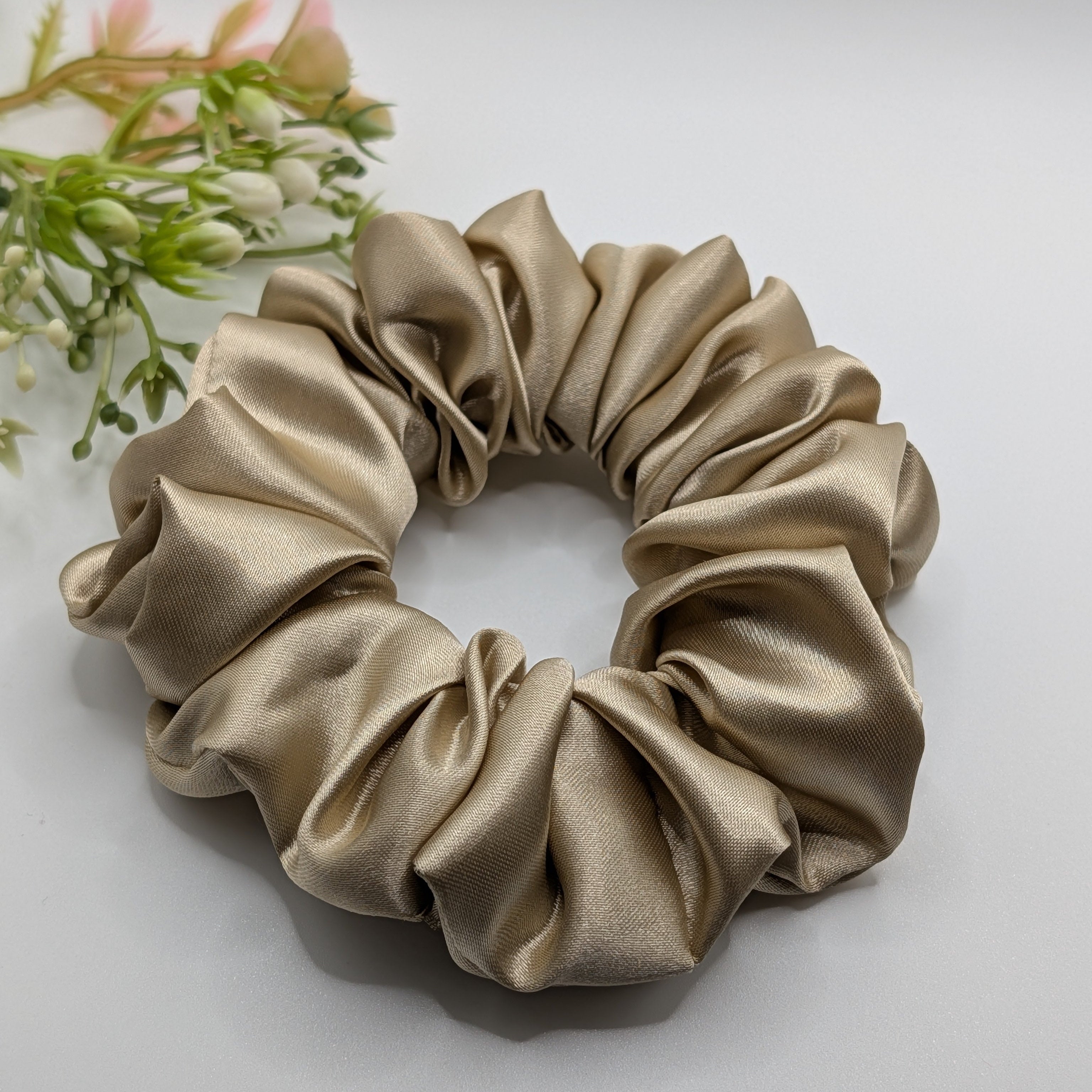 3er Set - High-quality texture detail of a champagne gold satin hair accessory.

Hochwertige Textur-Detailaufnahme eines champagner-goldenen Satin-Scrunchies.