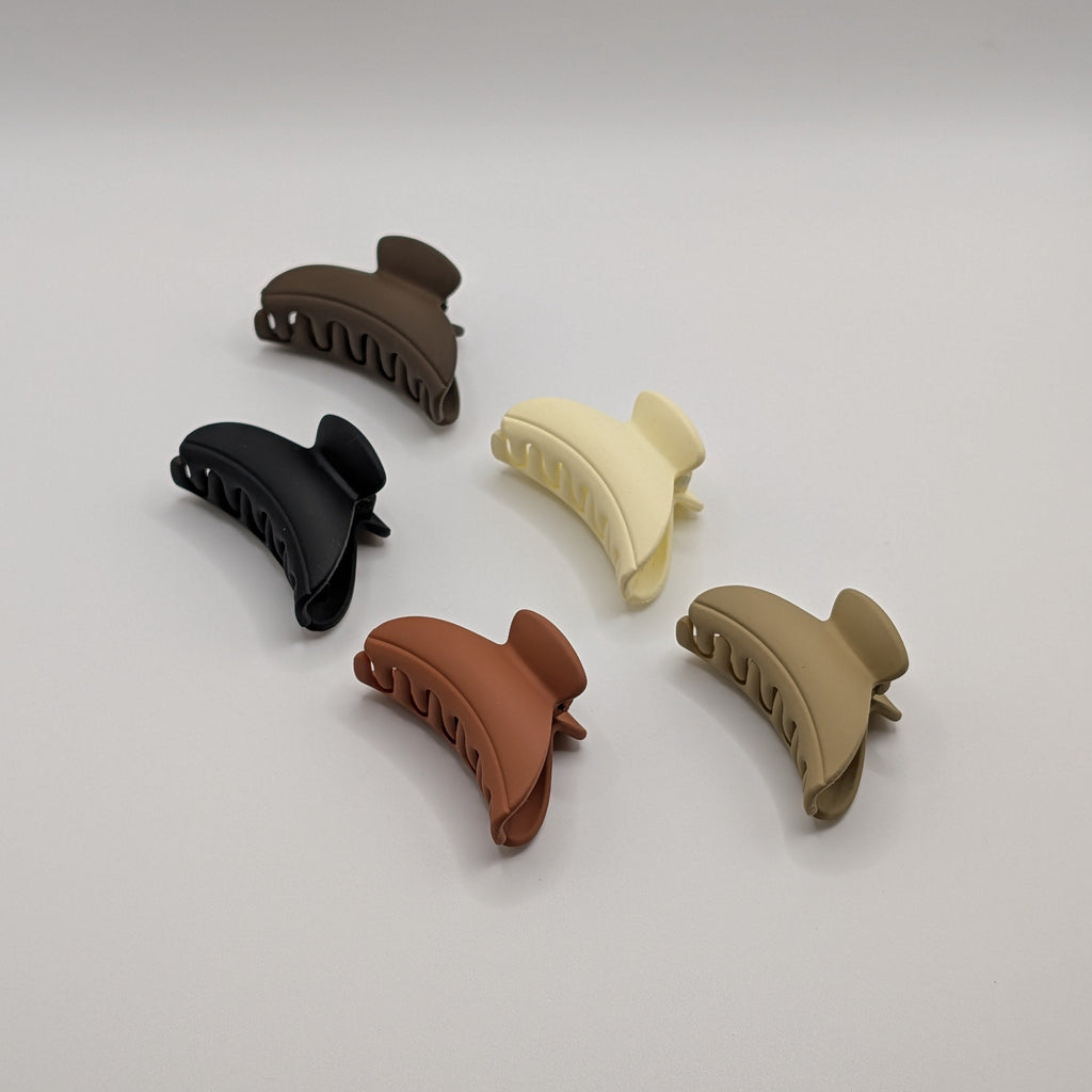 Angled shot of 5 aesthetic matte hair claws showing the ergonomic shape and size.

Seitliche Ansicht von 5 ästhetischen matten Haarklammern, die die Form betonen.