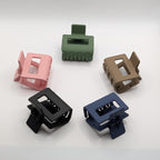 Angled shot of 5 rectangular hair claw clips arranged in a circle showing the depth and strong spring.	

Schräge Ansicht von 5 eckigen Haarklammern, kreisförmig angeordnet, zur Darstellung der Tiefe.