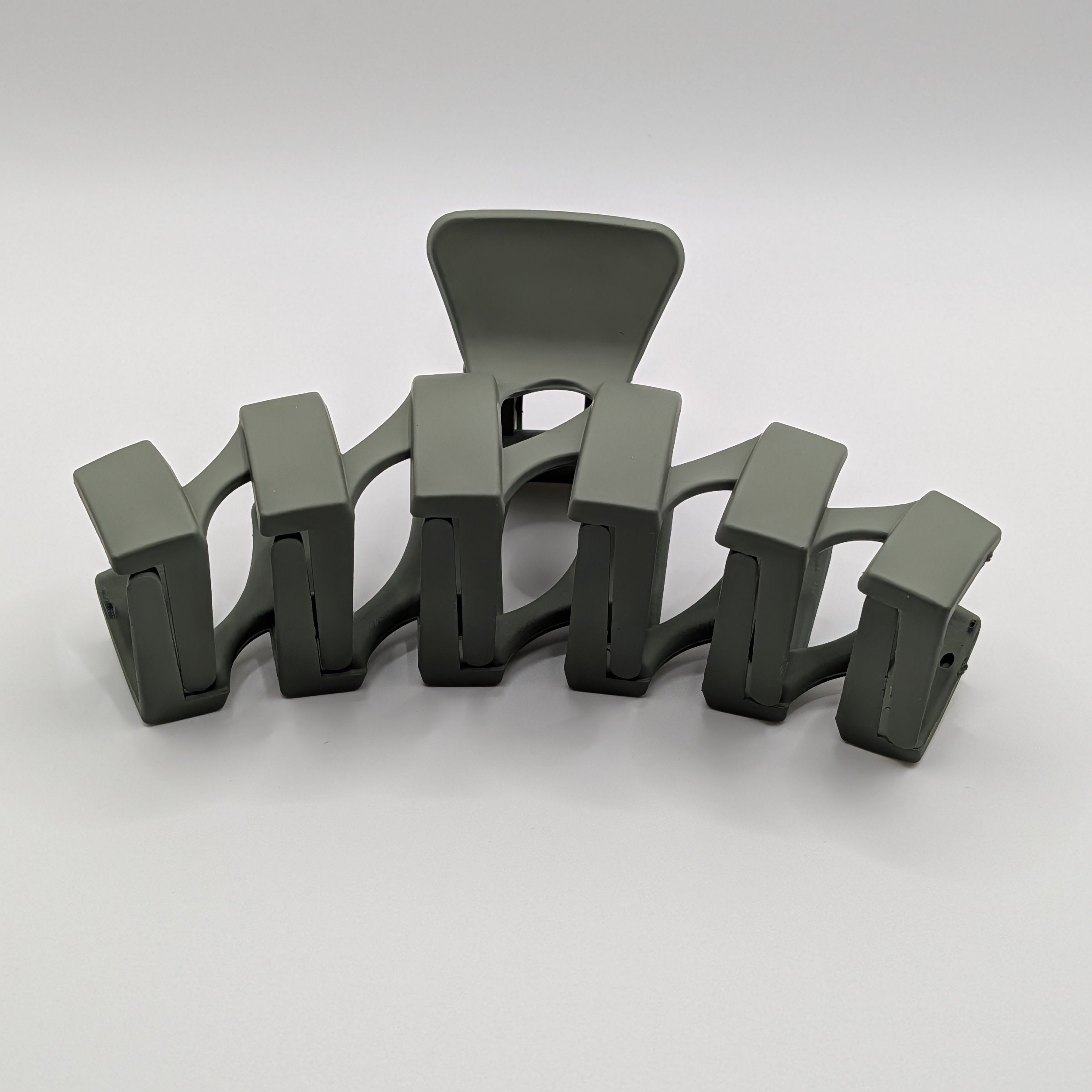 Olive Grün - Front perspective of a matte olive green geometric arched hair claw clip.

Frontalansicht einer matten olivgrünen geometrischen Haarklammer im Bogendesign.