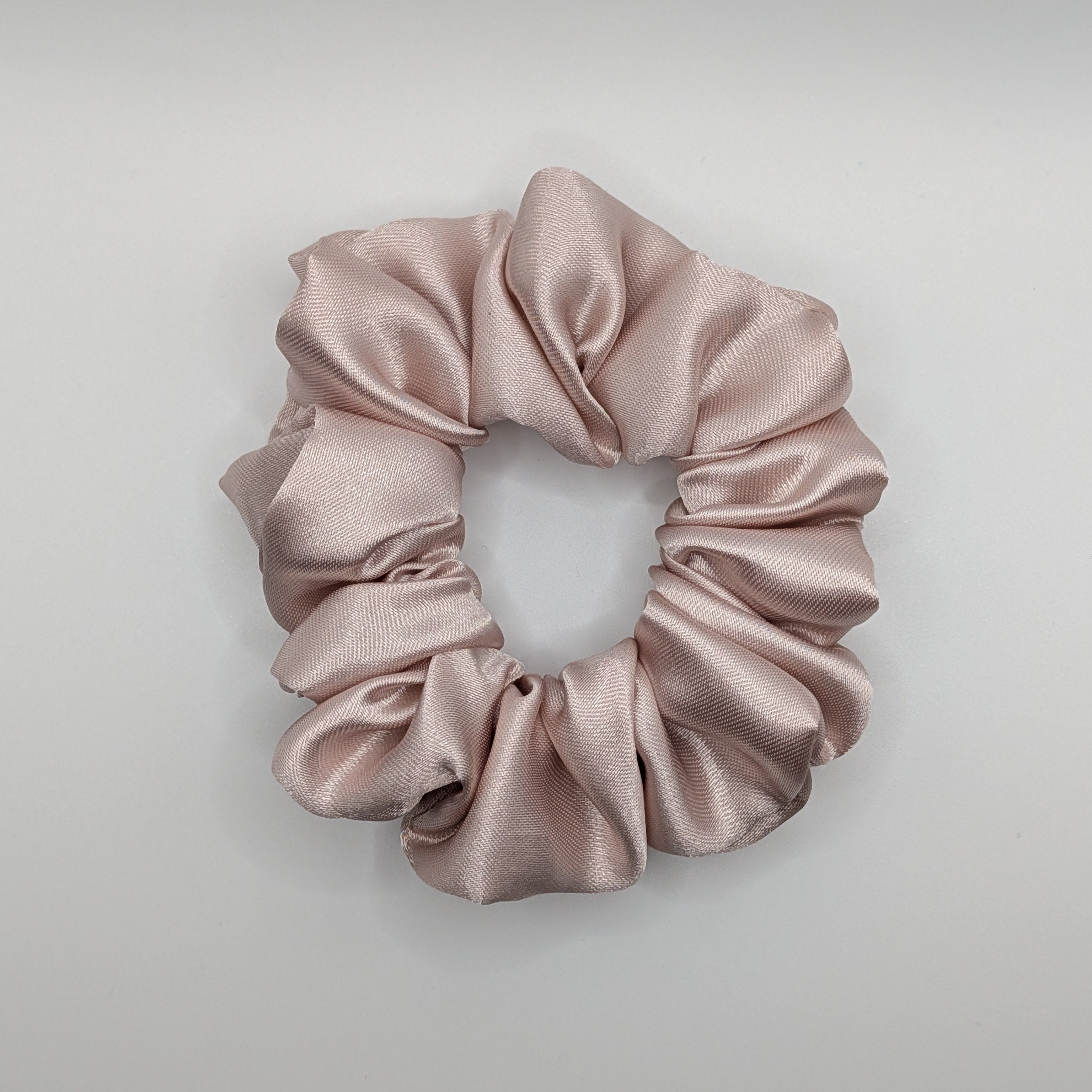 mittel - Top view of a medium rose satin hair tie showing silk texture.	

Draufsicht eines mittleren Satin-Haargummis mit Seidentextur.