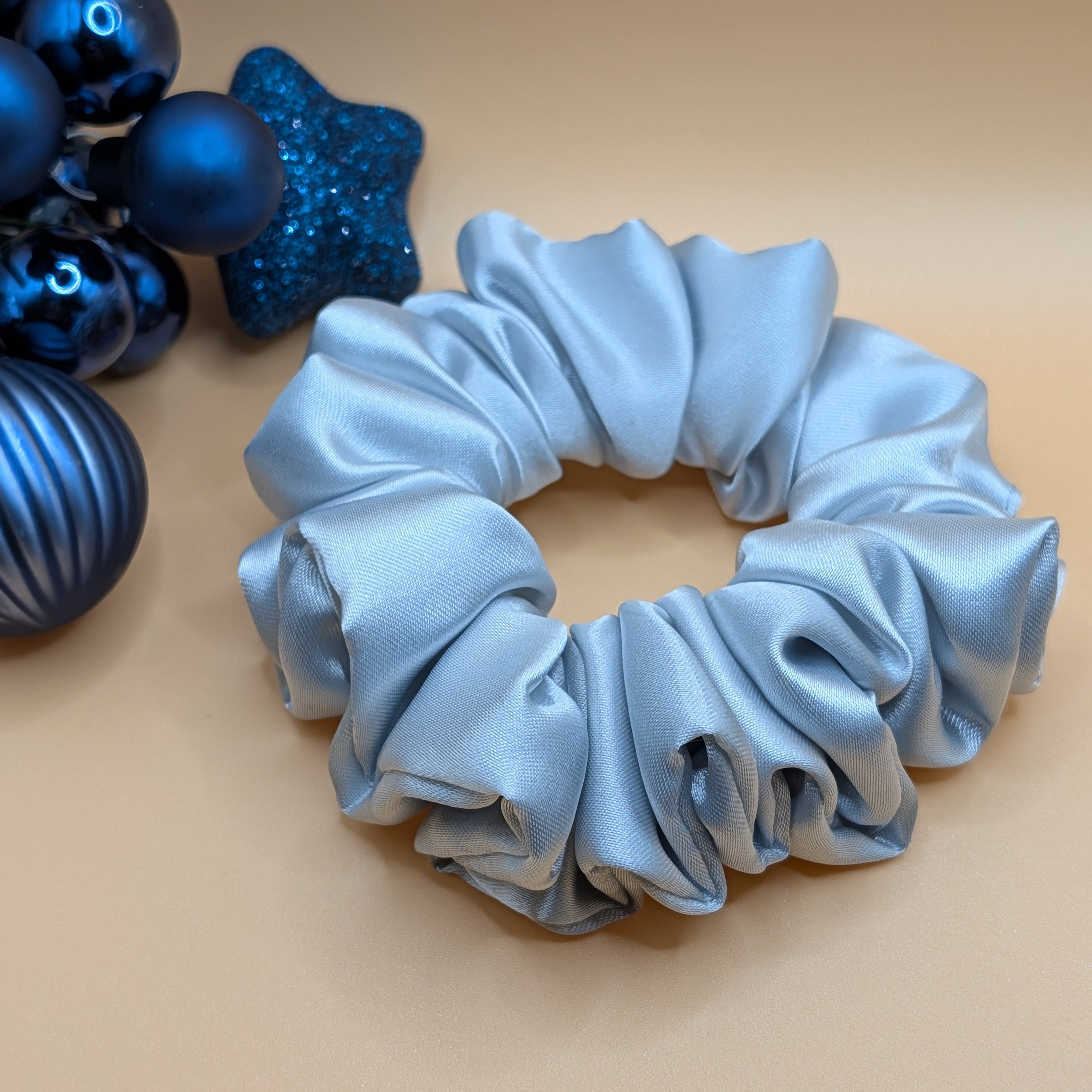 3er Set - Medium-sized silver satin scrunchie showing fabric texture and pleats.

Mittelgroßer silberner Satin-Scrunchie mit Detailansicht der Falten.