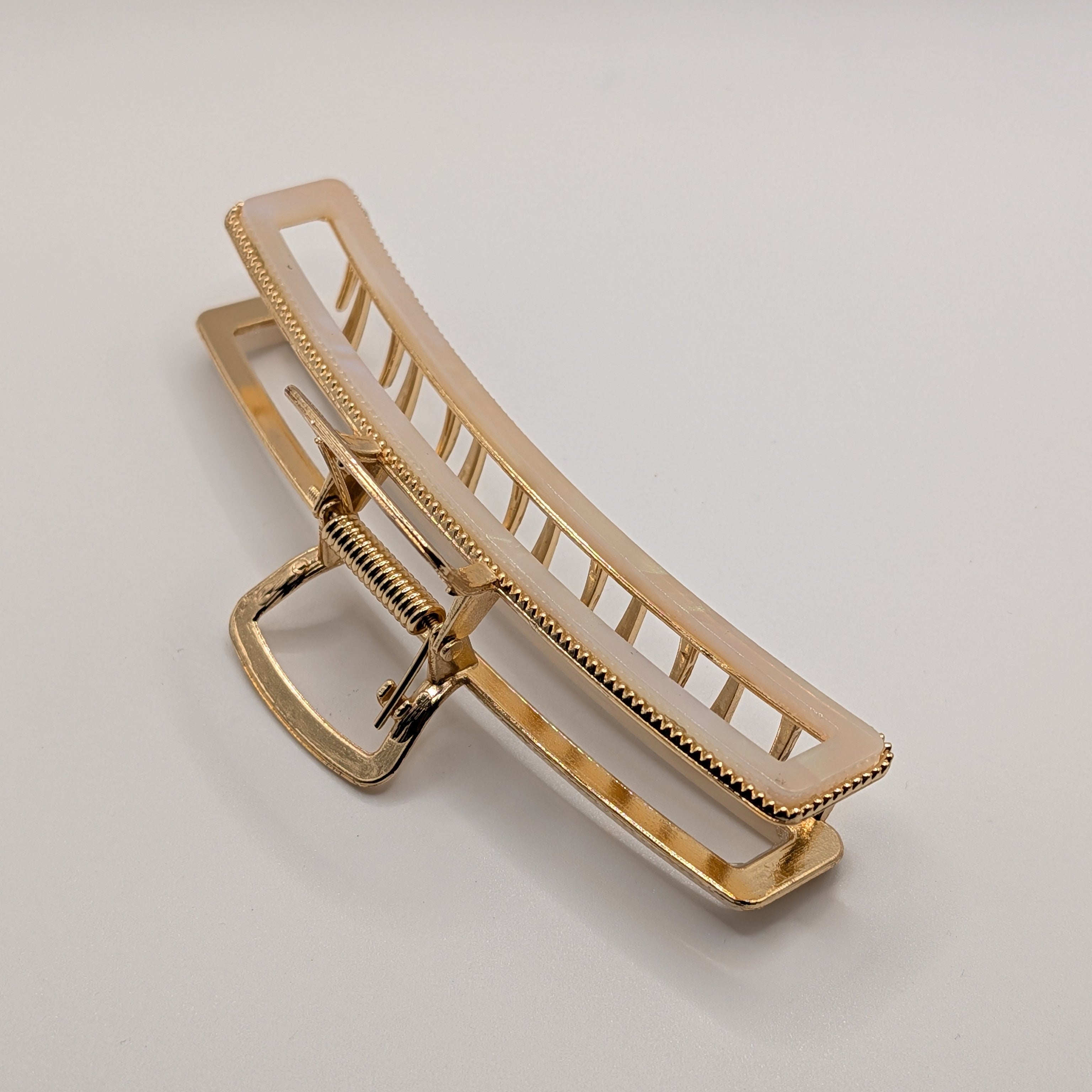 Perlweiß - "Metallic Ivory" 11cm Haarspange - Mercy Haaraccessoires

Nahaufnahme der goldenen Haarklammer mit Fokus auf die robuste Metallfeder.