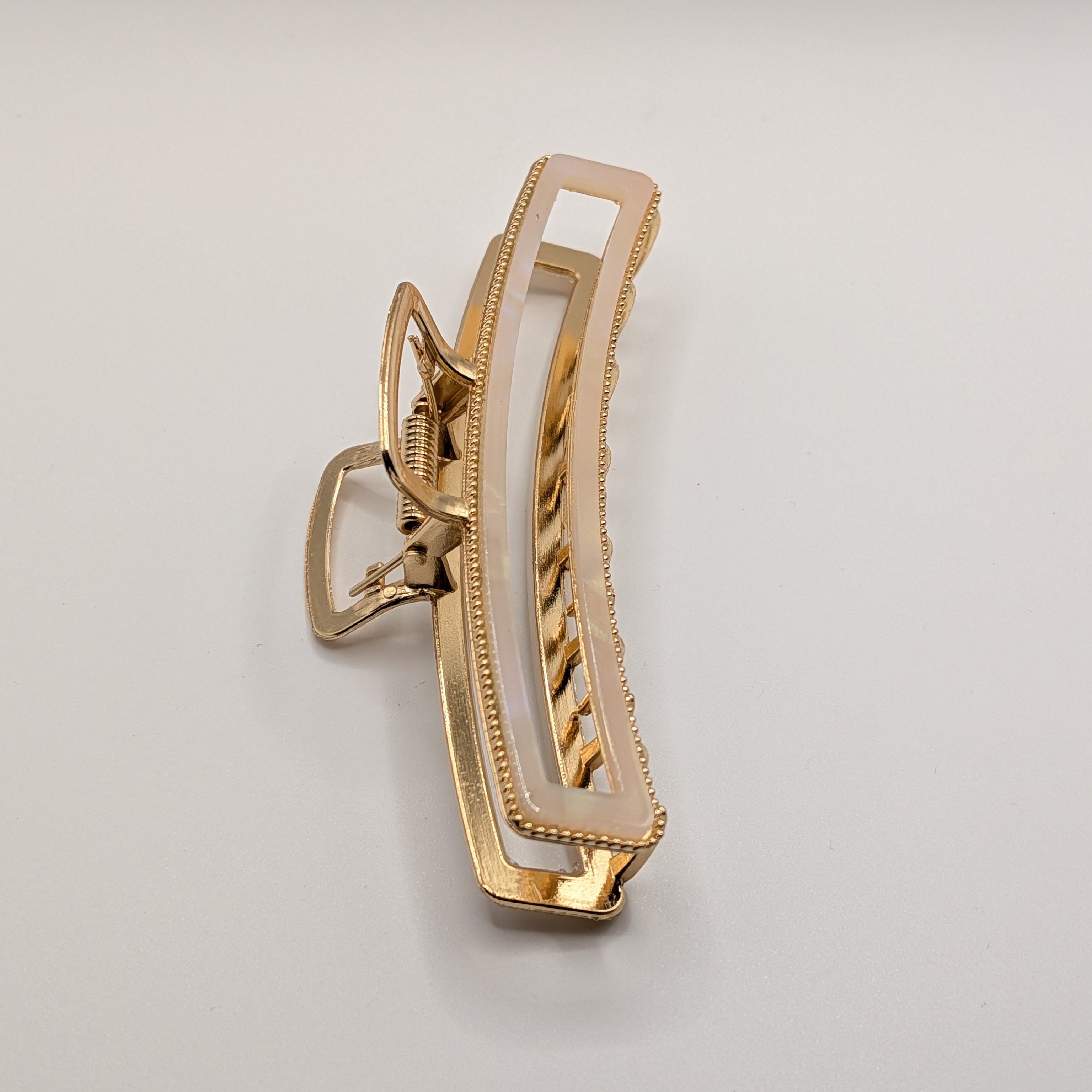 Perlweiß  - "Metallic Ivory" 11cm Haarspange - Mercy Haaraccessoires

Eckige Metall-Haarklammer in Gold mit weißem Perlmutt-Inlay in der Schrägansicht.