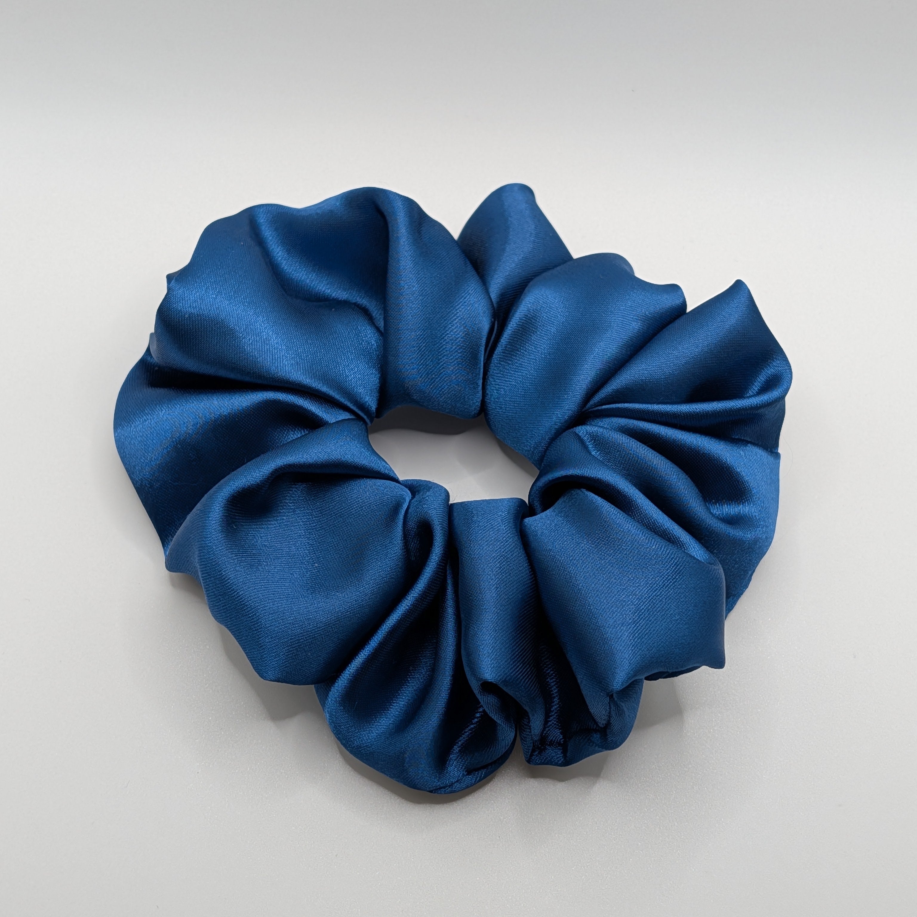 3er Set- Oversized navy blue satin scrunchie close-up view showing fabric texture.	

Großes XL Satin Haargummi in Dunkelblau Nahaufnahme der Stoffstruktur.