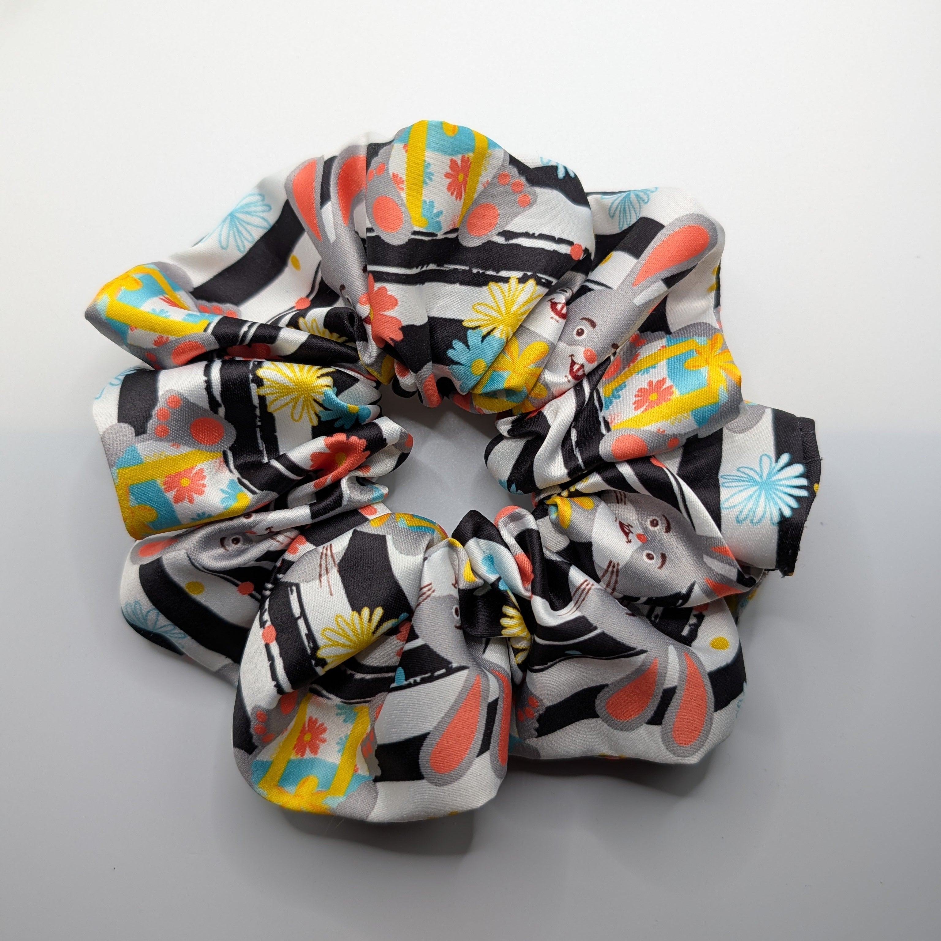 groß - Close-up of the large oversized rabbit print satin scrunchie.	

Nahaufnahme des großen XL-Satin-Haargummis mit Hasenmuster.