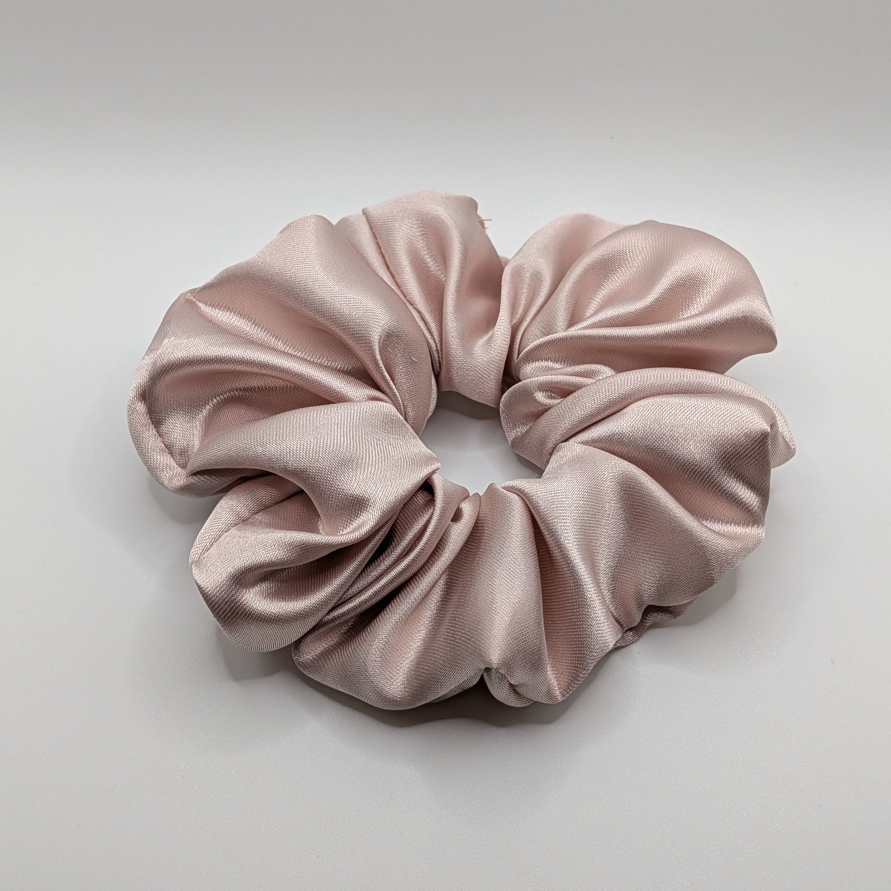groß - Oversized champagne rose satin scrunchie showing soft fabric texture.

Übergroßes Satin-Haargummi in Champagner-Rosa mit weicher Stoffstruktur.