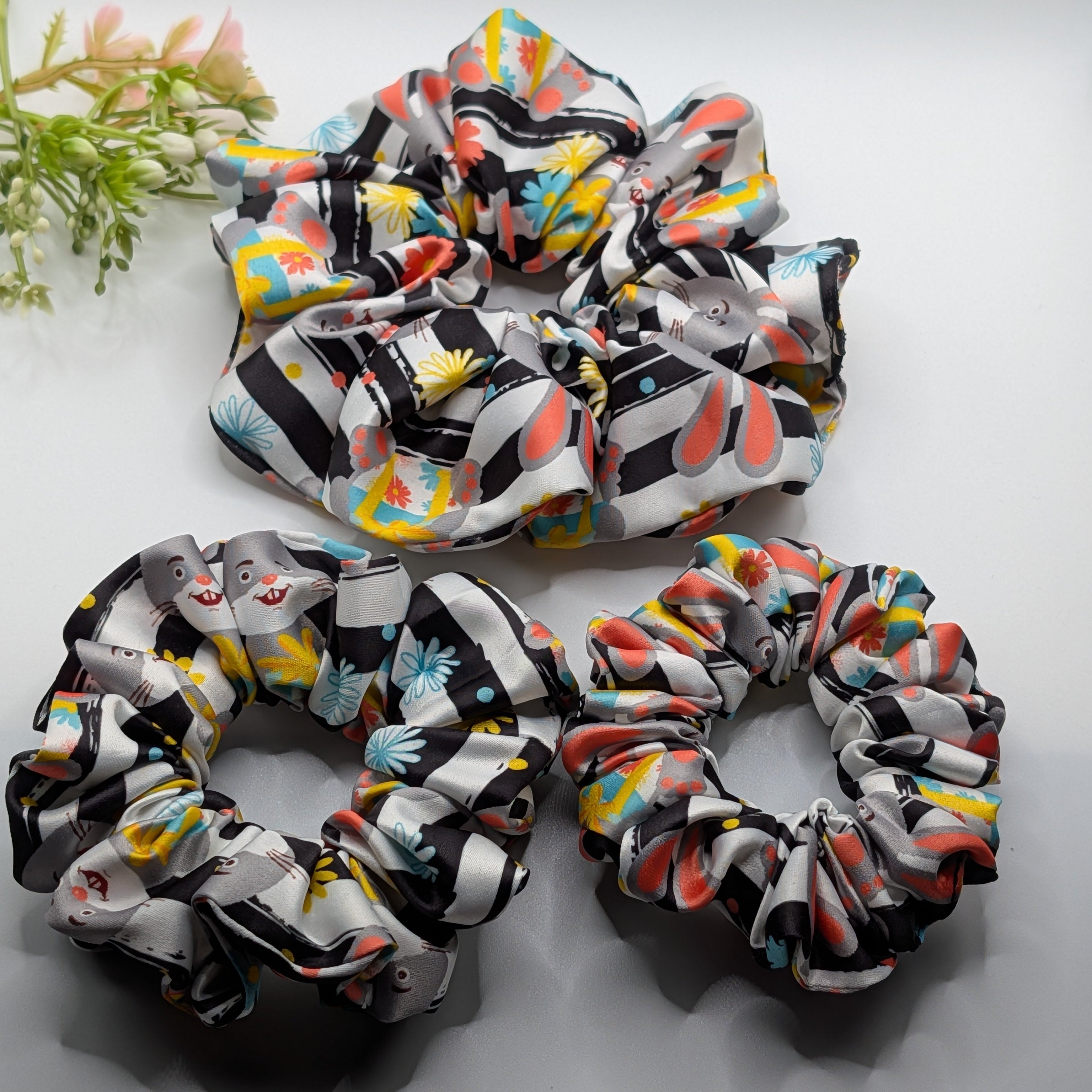 3er Set - Set of 3 rabbit print satin scrunchies in large, medium, and small sizes.

3er-Set Satin-Haargummis mit Hasen-Print in drei Größen.