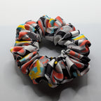 klein - Rabbit print satin scrunchie laid flat next to decorative flowers.	

Satin-Haargummi mit Hasen-Print neben dekorativen Blumen.