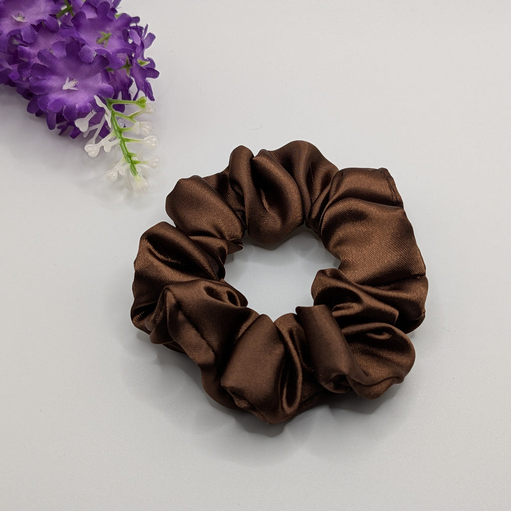 3er Set - Mittleres braunes Satin Haargummi neben violetten Blumen.

Medium brown satin hair tie next to purple flowers