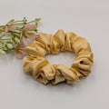 "Champagne Glow" Satin-Scrunchie - Mercy Haaraccessoires

Ein schmales, kleines Satin-Scrunchie in Gold-Optik auf einem schlichten, hellen Hintergrund.