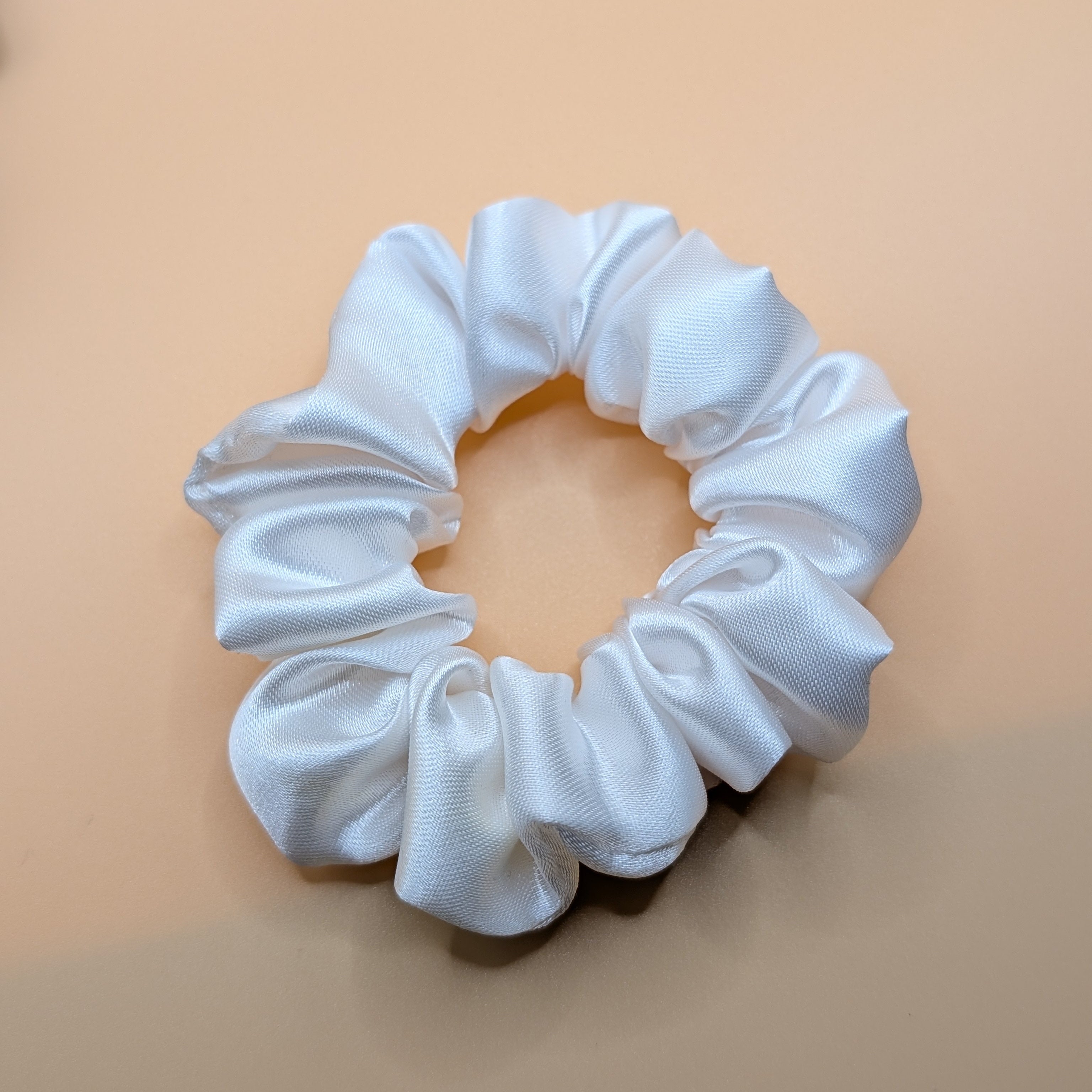 klein - Nahaufnahme eines weißen Satin Haargummis

Close-up of a single white satin scrunchie