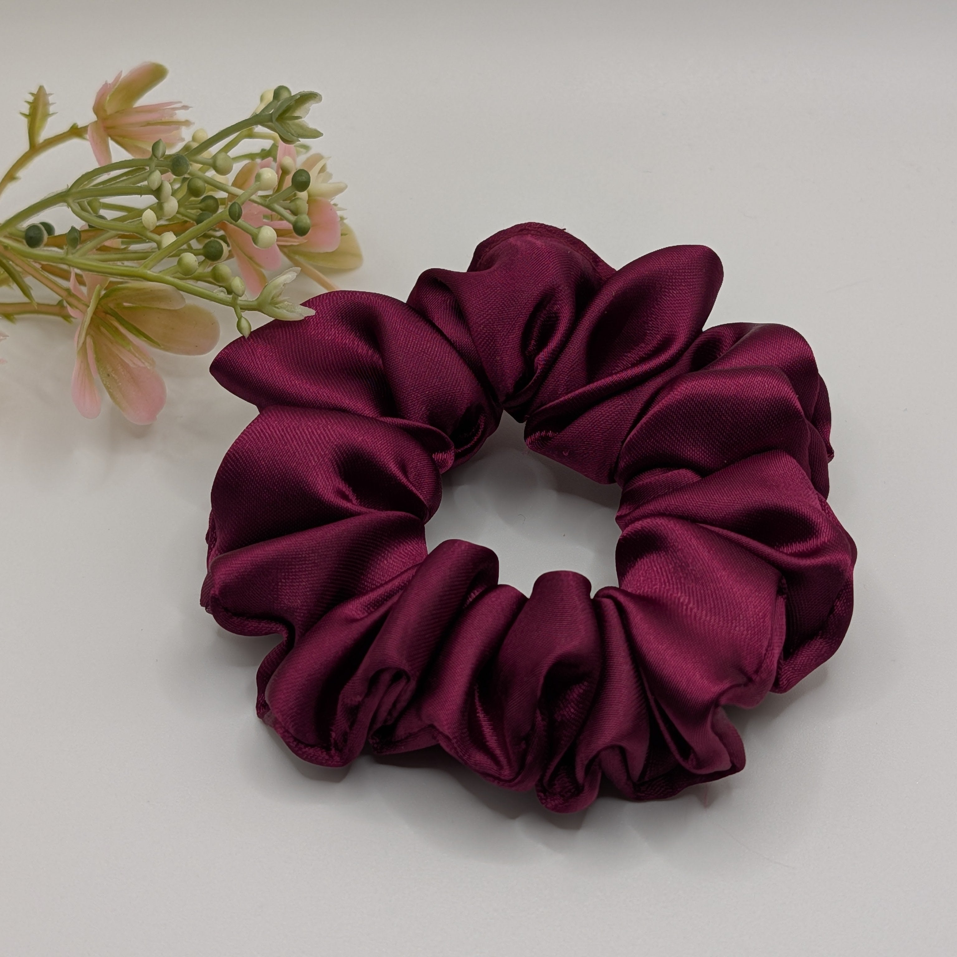 "Wild Berry" Satin-Scrunchie - Mercy Haaraccessoires

Ein mittelgroßes weinrotes Satin-Scrunchie mit schöner Raffung, präsentiert neben dekorativen Zweigen.