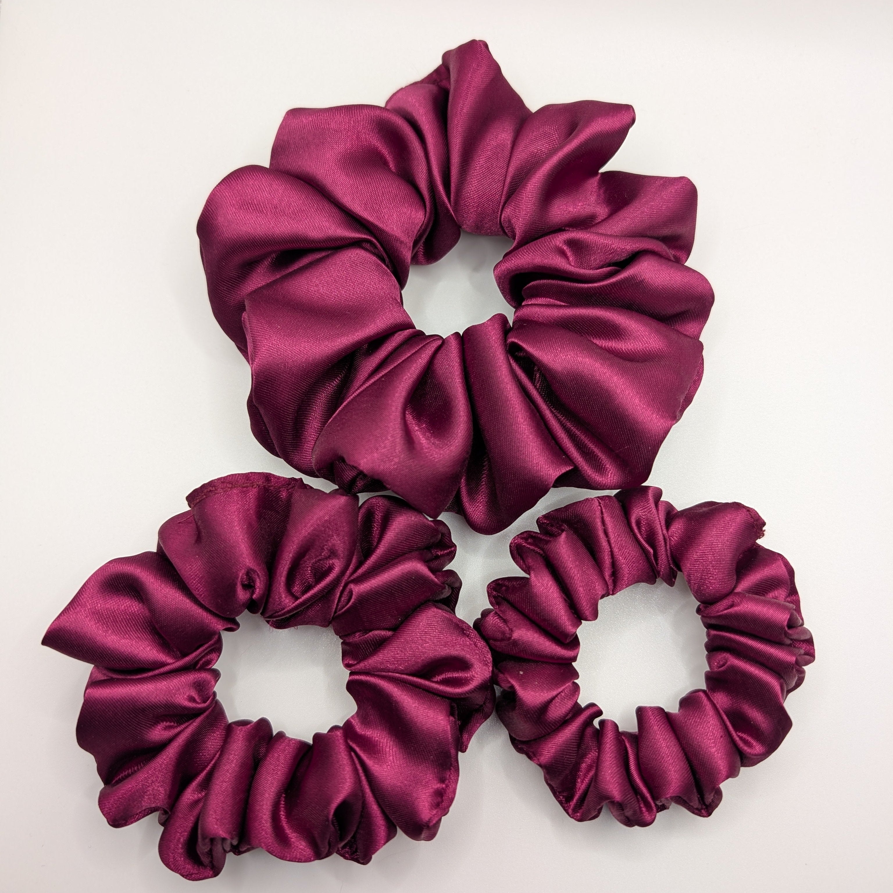 "3er-Set Wild Berry" Satin-Scrunchie - Mercy Haaraccessoires

Ein Set aus drei weinroten Satin-Scrunchies in den Größen Klein, Mittel und Groß für vielseitige Stylings.
