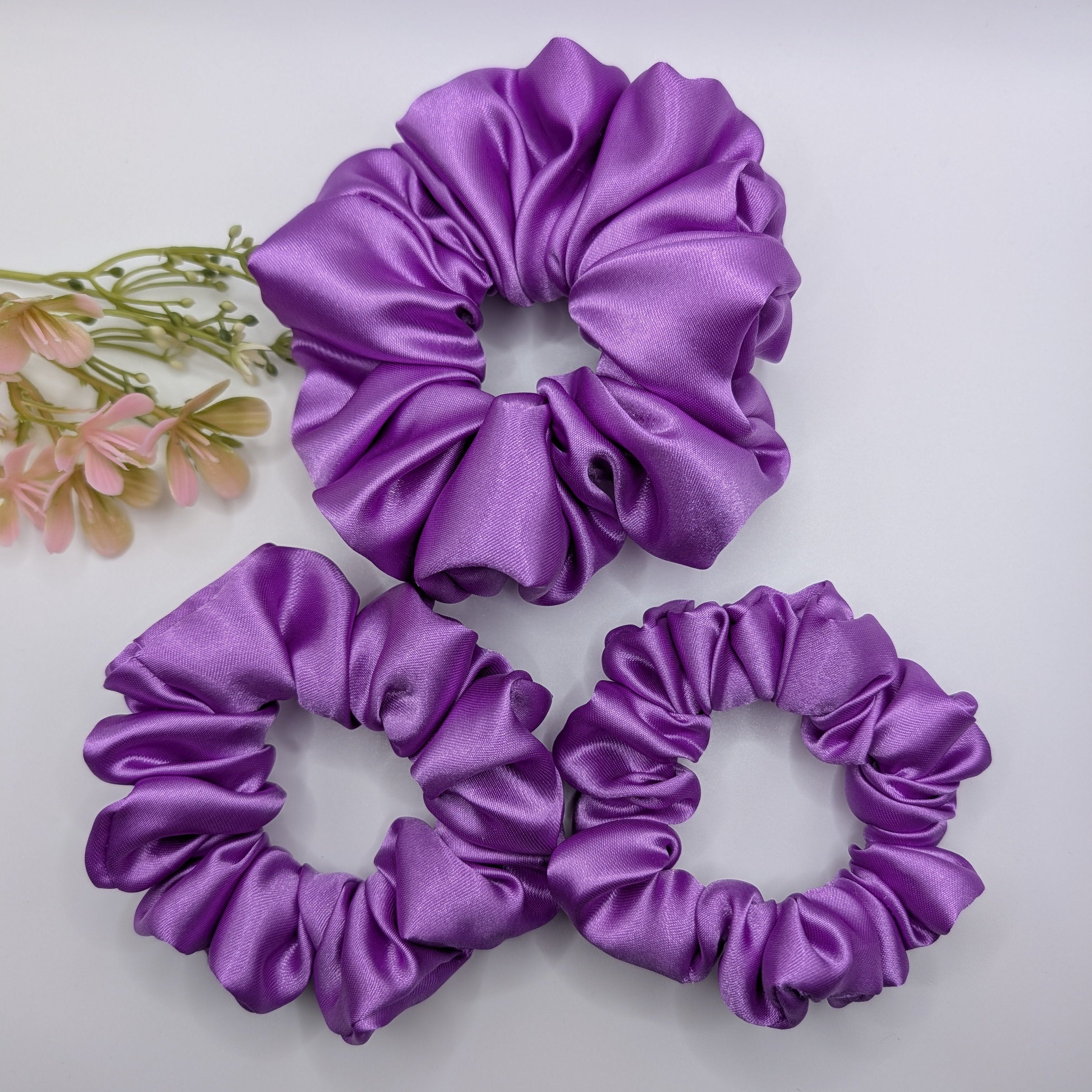 "3er-Set Royal Amethyst" Satin-Scrunchie - Mercy Haaraccessoires

Ein dreiteiliges Set violetter Satin-Scrunchies in den Größen Groß, Mittel und Klein, übersichtlich angeordnet auf weißem Grund.