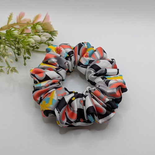 3er Set - Smallest scrunchie of the set featuring coral and yellow accents.	

Kleinstes Haargummi des Sets mit korallen- und gelben Akzenten.