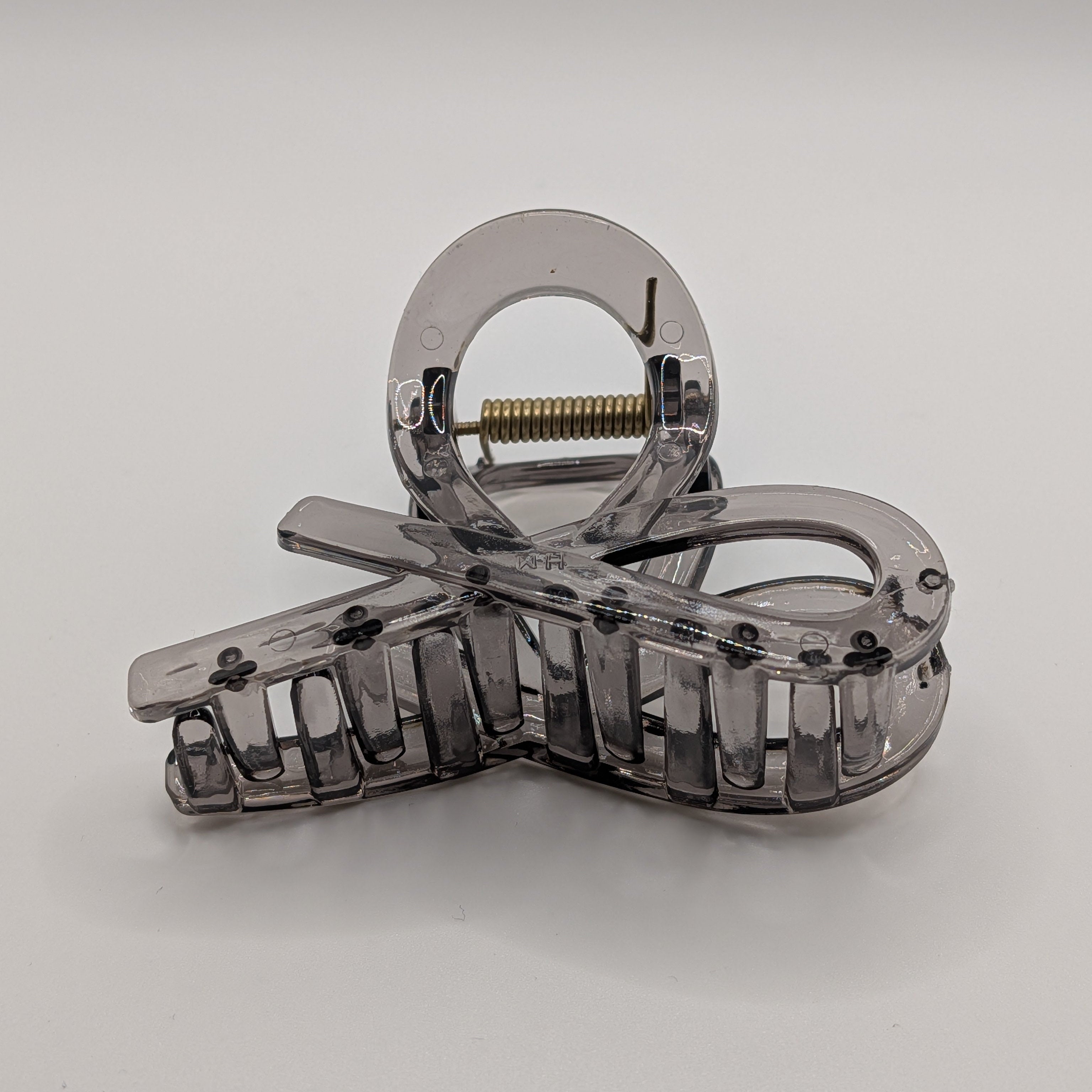 Rauchschwarz - Front view of a transparent smokey grey bow-shaped hair claw clip.

Vorderansicht einer transparenten rauchgrauen Haarklammer in Schleifenform.