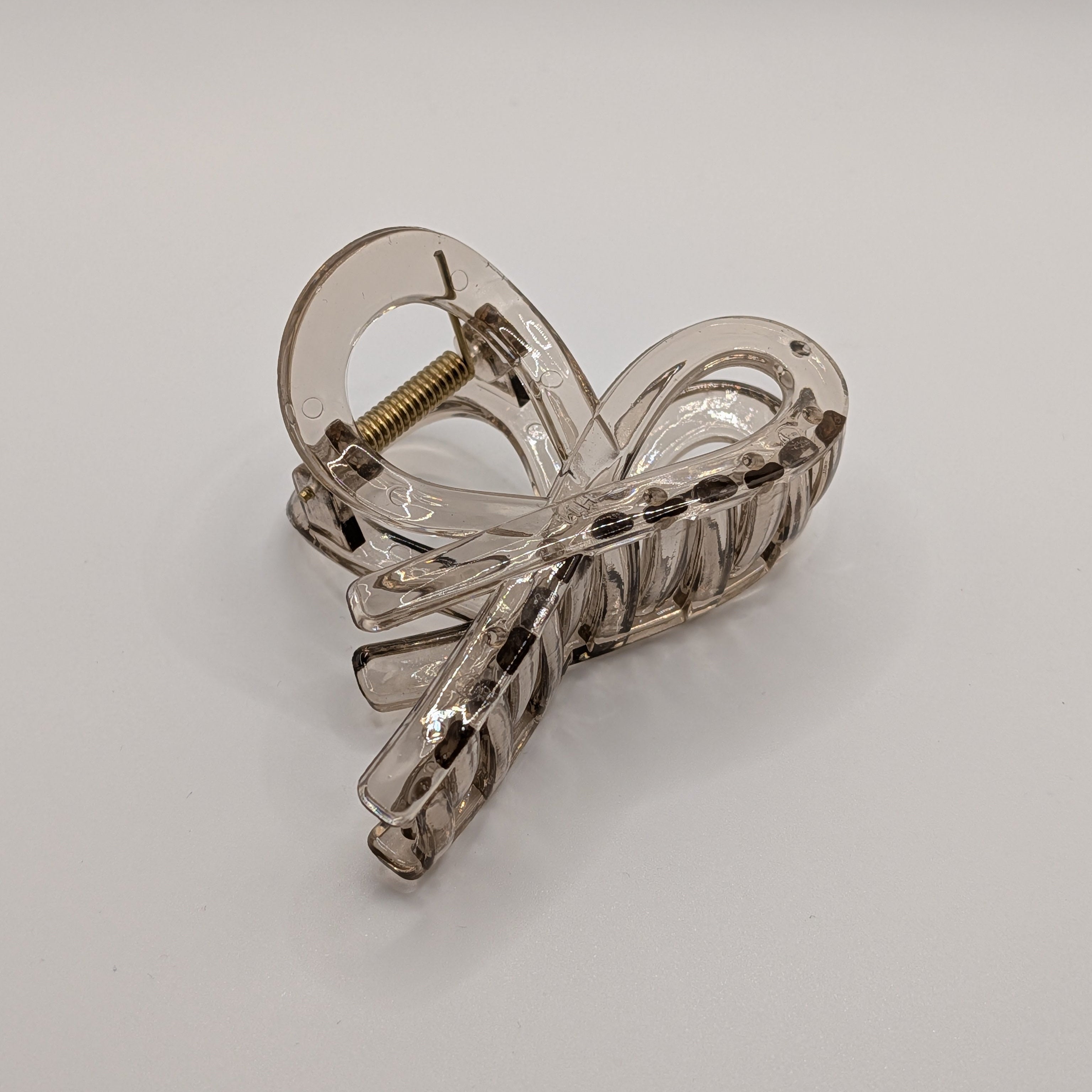 Transparent - Angled view of the clear nude-grey hair clip showing the infinity loop design.

Schräge Ansicht der klaren nude-grauen Haarklammer im Infinity-Loop-Design.